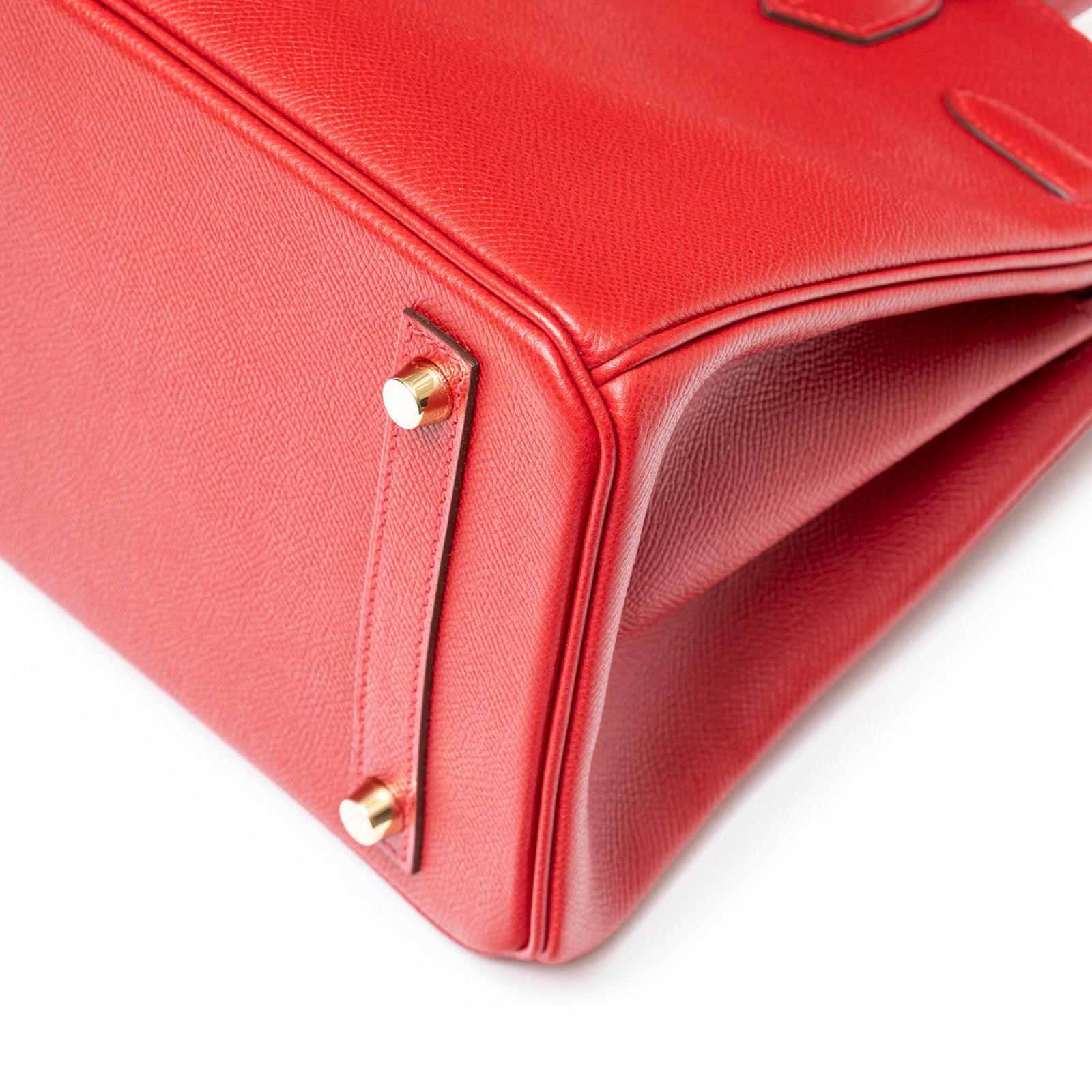 Close-up of bottom corner showing red Epsom leather and gold hardware on Hermès Birkin 30 Rouge Casaque Epsom Gold Hardware