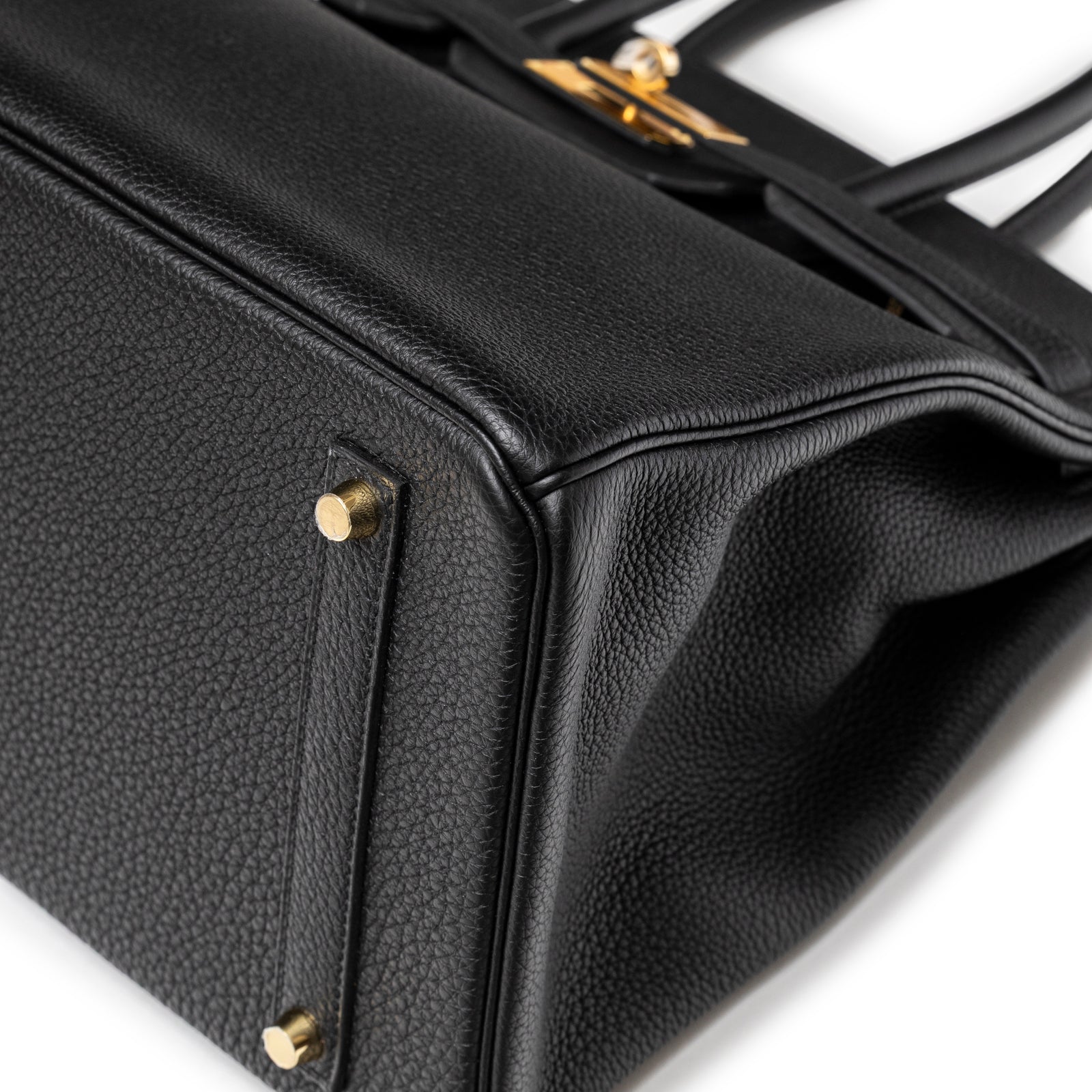 Close-up of Hermès Birkin 35 Black Togo Gold Hardware base corner showing grainy leather texture and gold studs detail