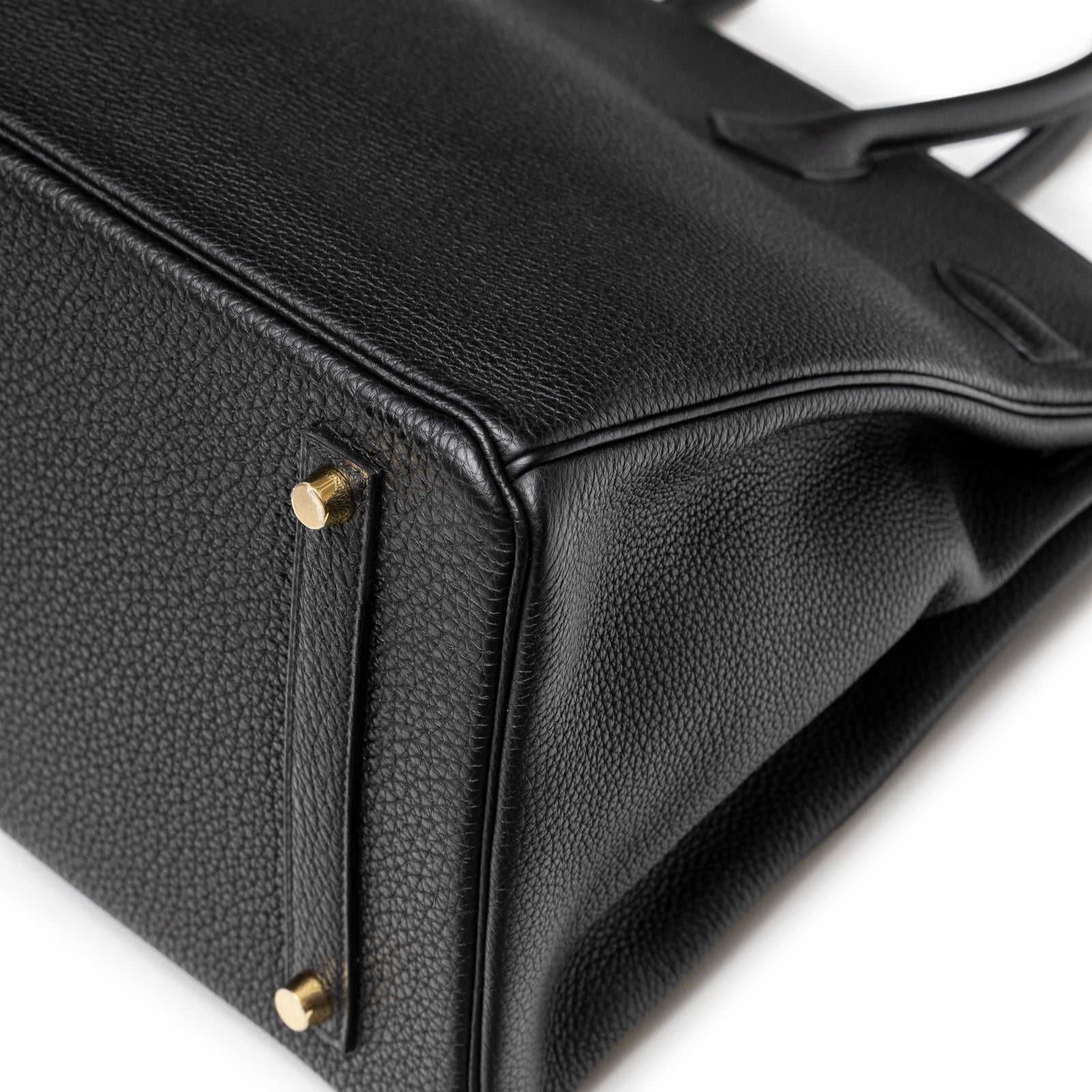Close-up of Hermès Birkin 35 Black Togo Gold Hardware focusing on bottom corner with gold studs and textured leather