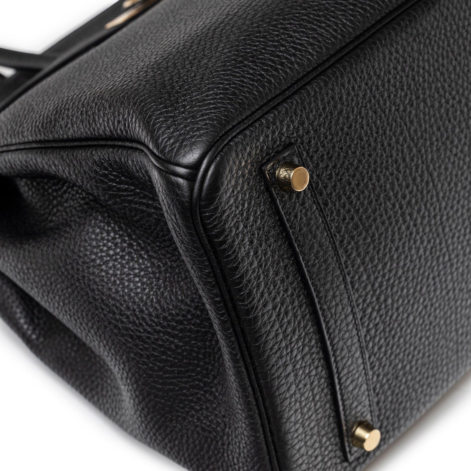 Close-up of bottom corner and gold feet on Hermès Birkin 35 Black Togo Gold Hardware handbag textured leather