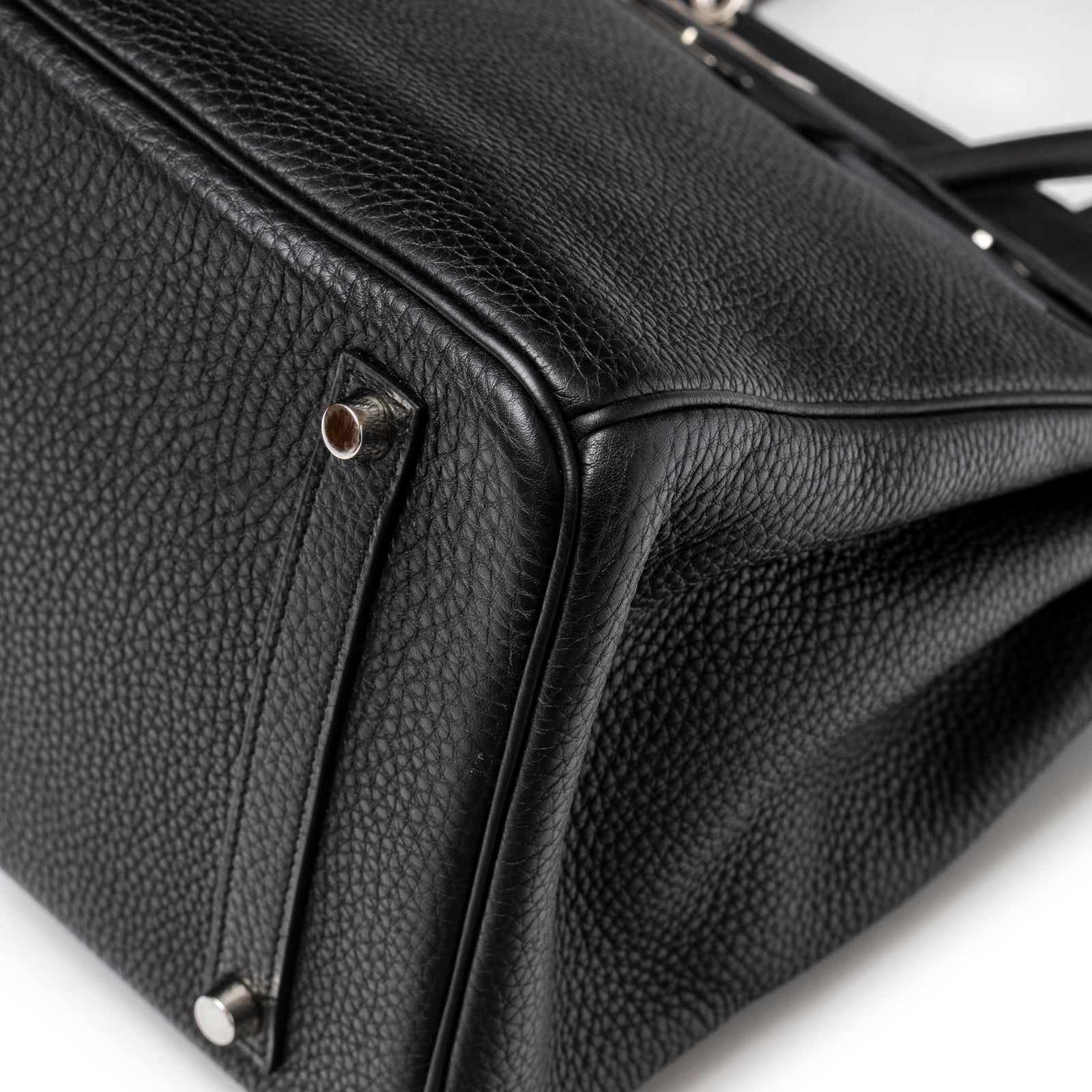 Close-up angled view of Hermès Birkin 35 Black Togo Palladium Hardware showing texture and metal feet detail.