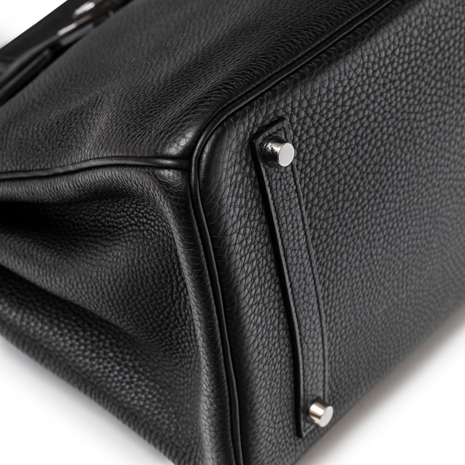 Close-up of bottom corner on Hermès Birkin 35 Black Togo Palladium Hardware highlighting textured leather and metal feet protection.