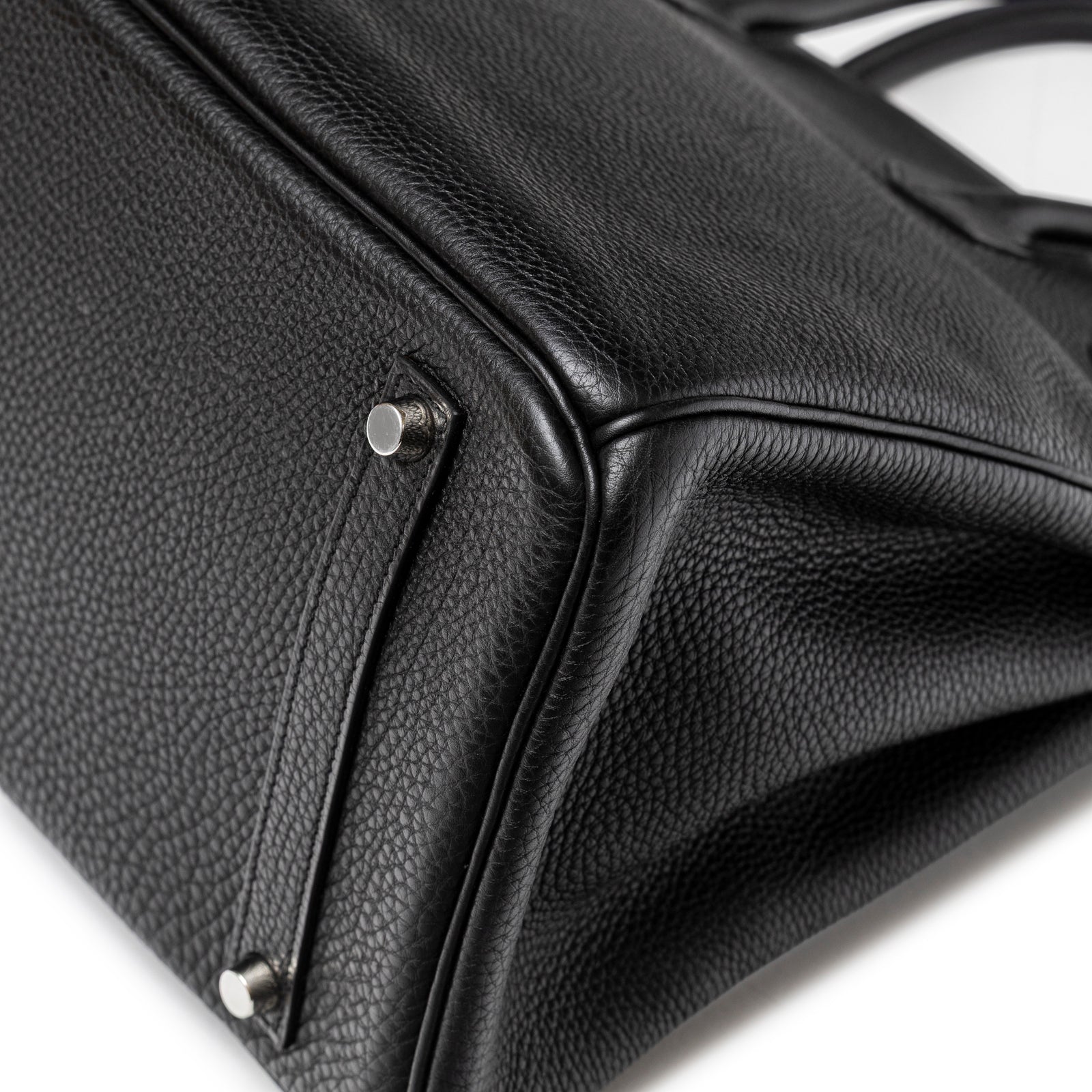 Close-up bottom view of Hermès Birkin 35 Black Togo Palladium Hardware showing pebbled leather and metal feet.