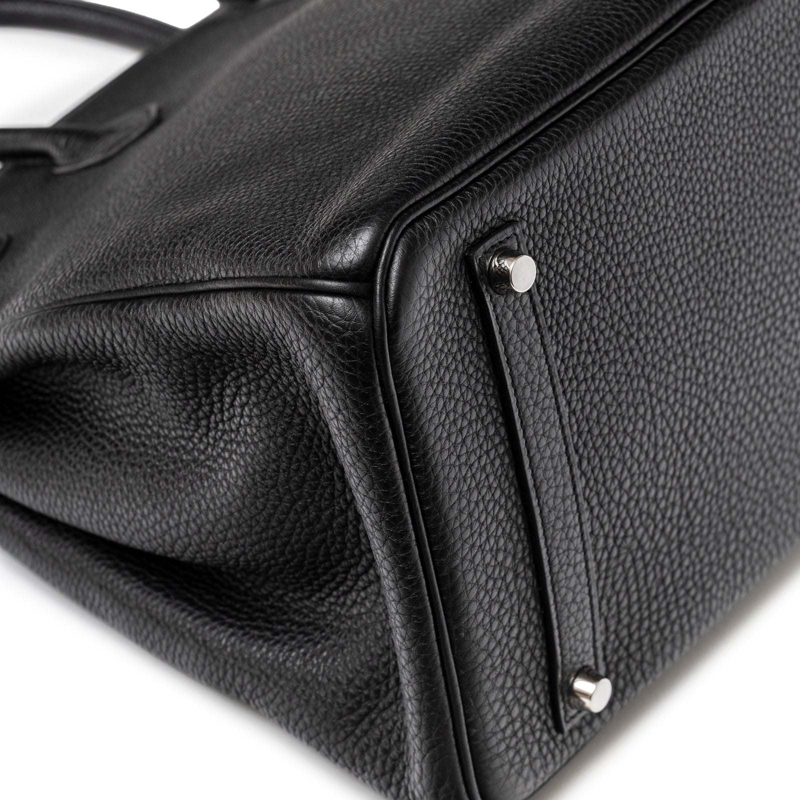 Close-up of bottom corner on Hermès Birkin 35 Black Togo Palladium Hardware showing textured leather and metal feet.