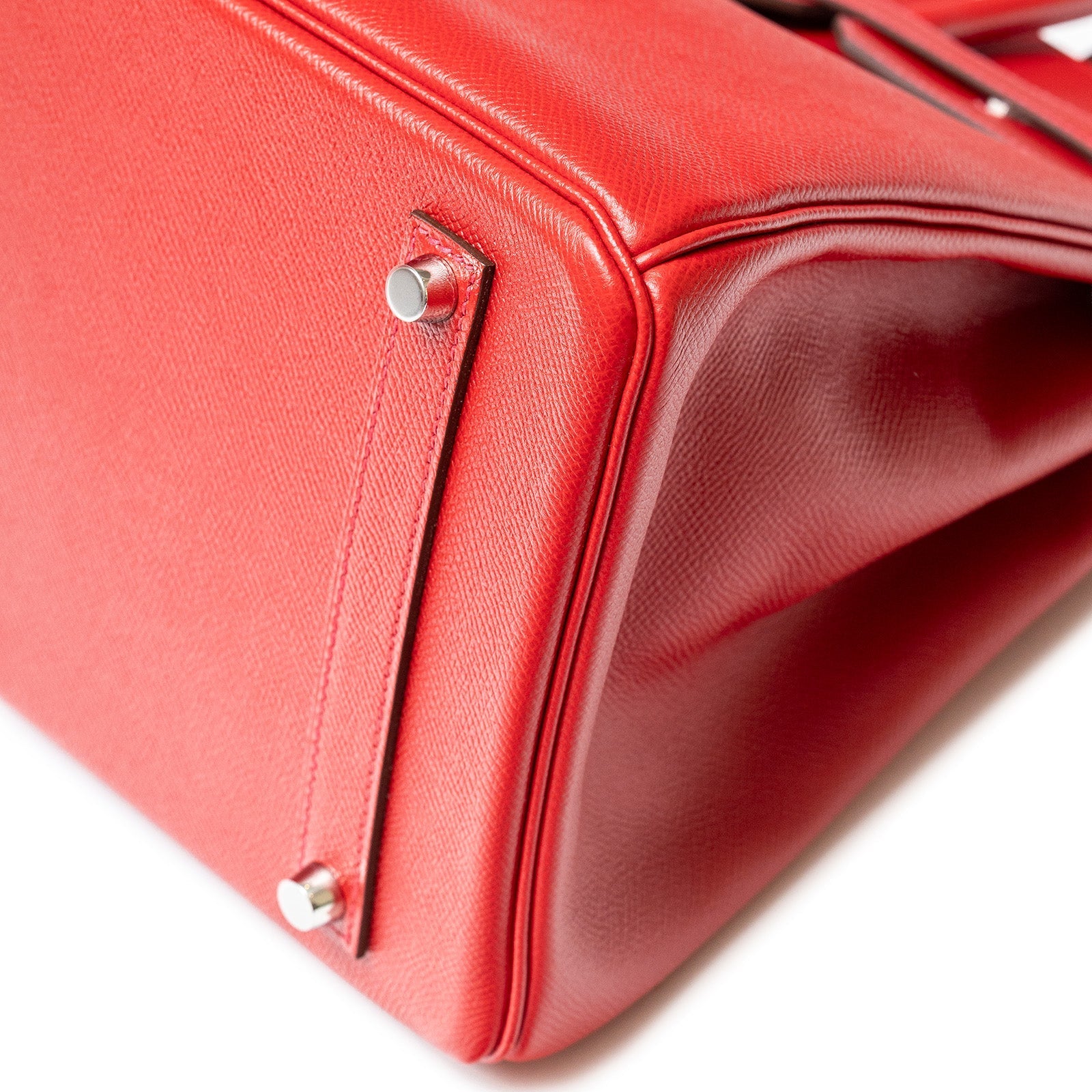 Close-up of Hermès Birkin 35 Rouge Casaque Epsom leather bottom with palladium hardware feet detail.