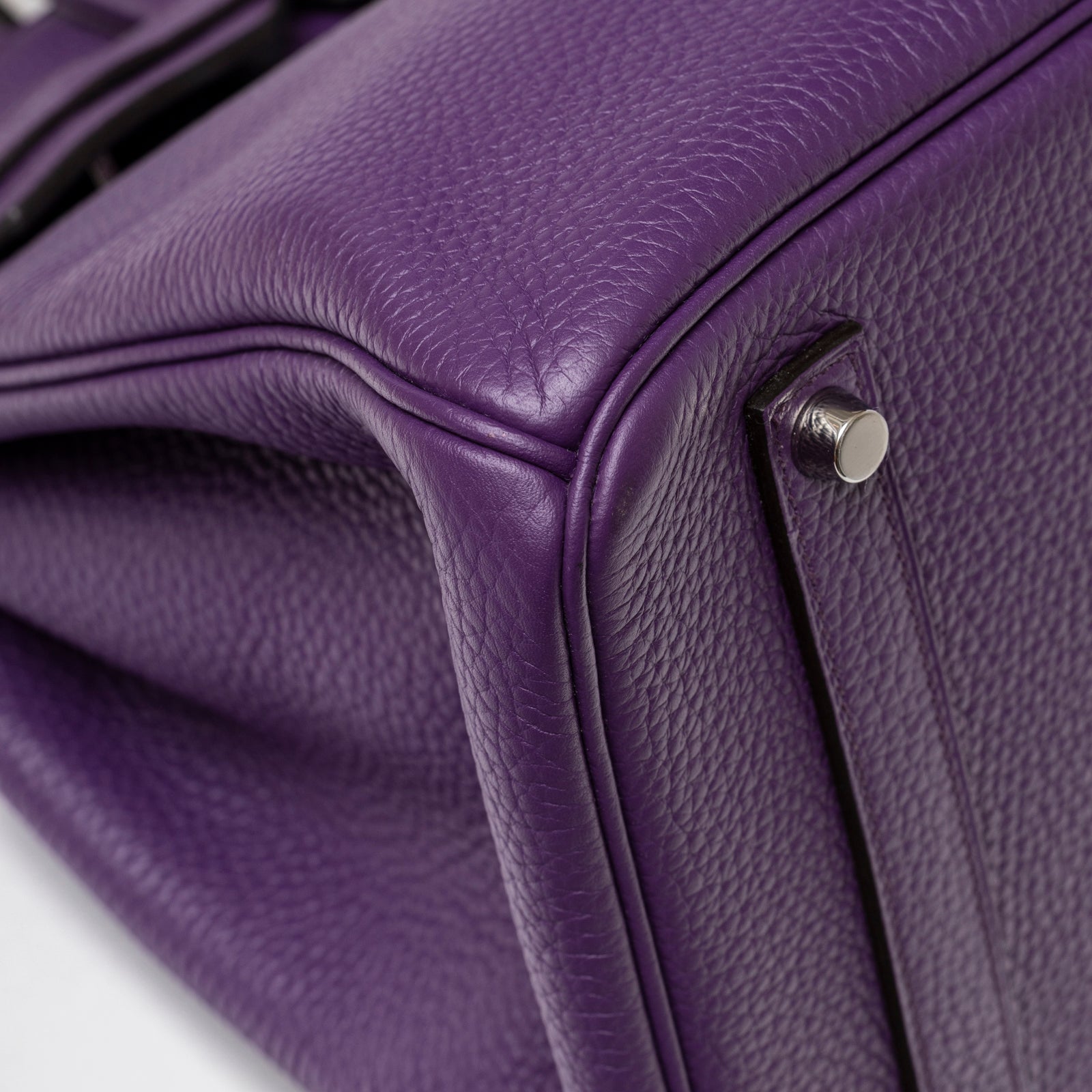 Close-up of palladium hardware feet and textured violet leather corner on Hermès Birkin 35 Violet Togo Palladium Hardware