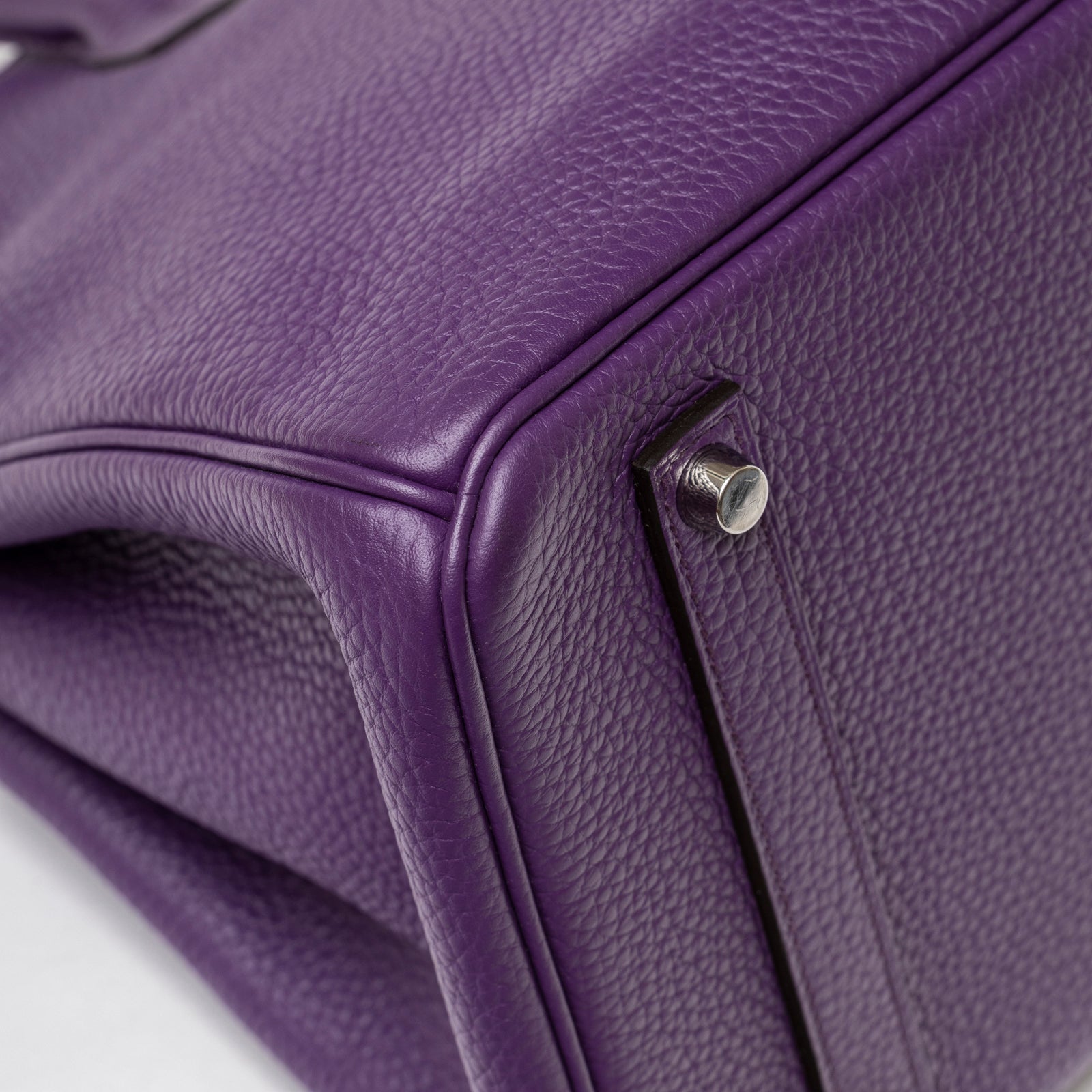 Close-up of the violet pebbled leather corner and palladium hardware foot on Hermès Birkin 35 Violet Togo Palladium Hardware
