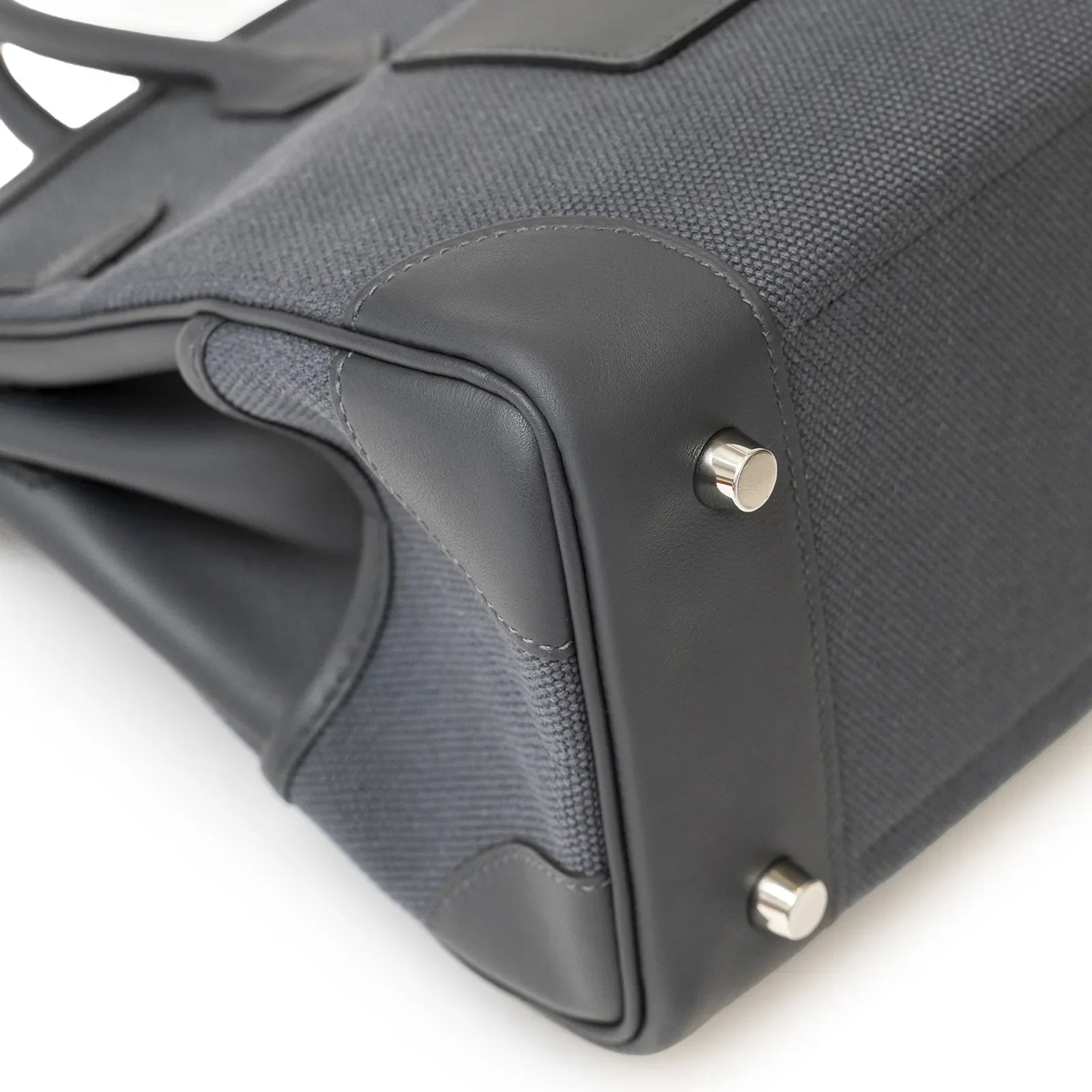 Close-up angled view of Hermès Birkin Cargo 25 corner showing gris misty canvas and palladium hardware feet