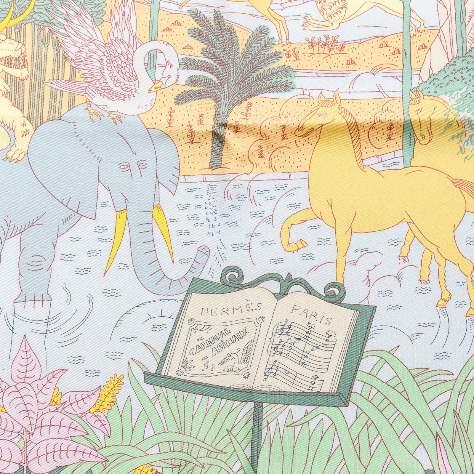 Close-up of Hermès Carre 90 Le Carnaval des Animaux Silk Scarf Blue Glacier Jaune Vif Gris featuring animals and musical notes design