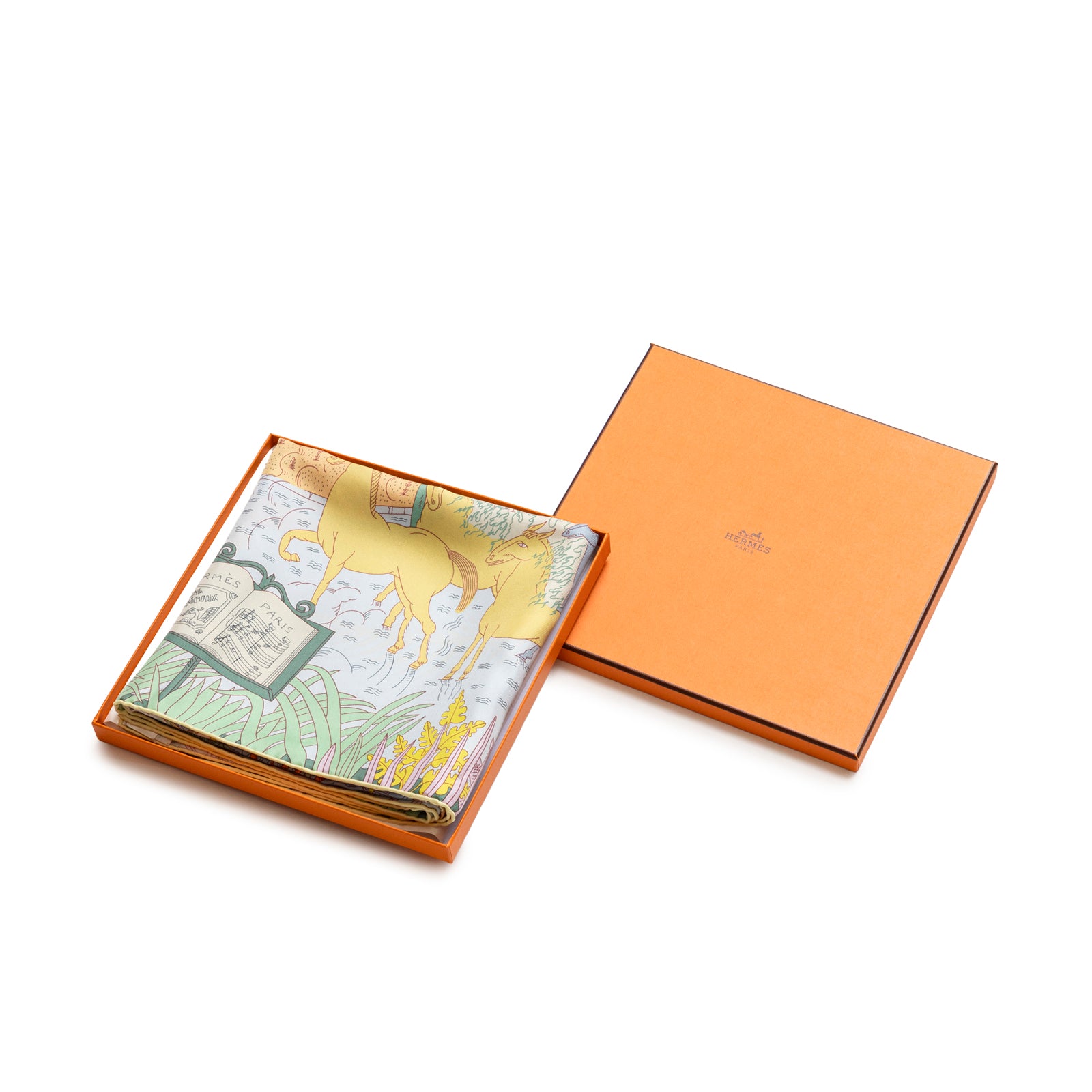 Folded Hermès Carre 90 Le Carnaval des Animaux Silk Scarf Blue Glacier Jaune Vif Gris in orange box with lid beside it