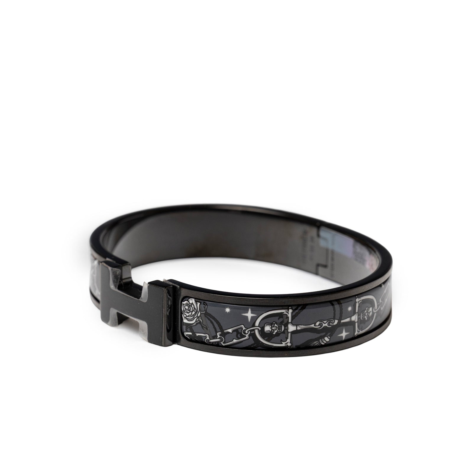 Angled view of Hermès Clic HH C'est la Fete So Black Bracelet Grand Classique with black enamel and silver motifs
