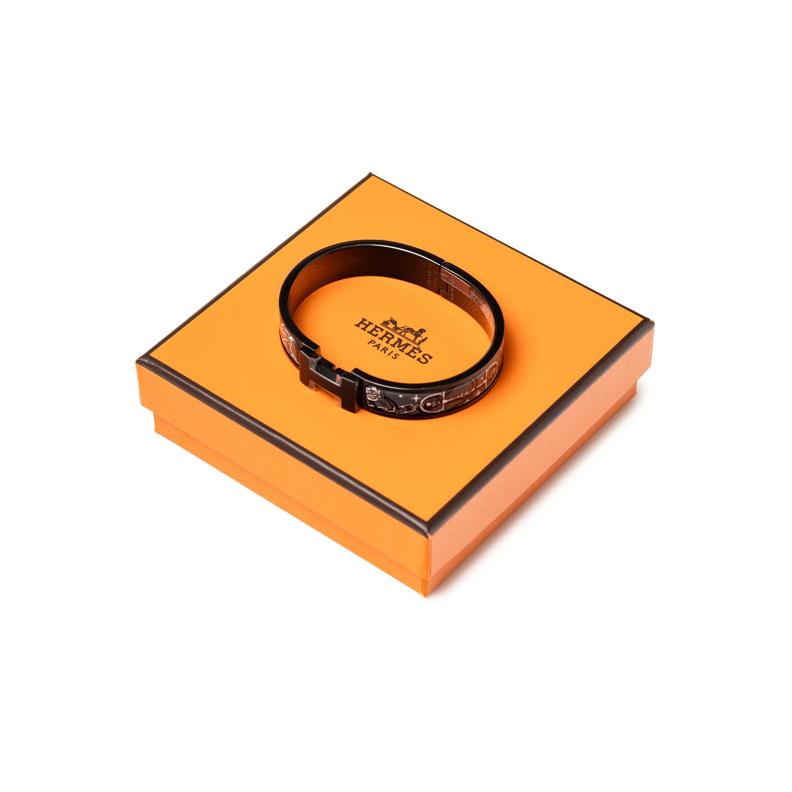 Top-down view of Hermès Clic HH C'est la Fete So Black Bracelet Grand Classique on orange box with logo