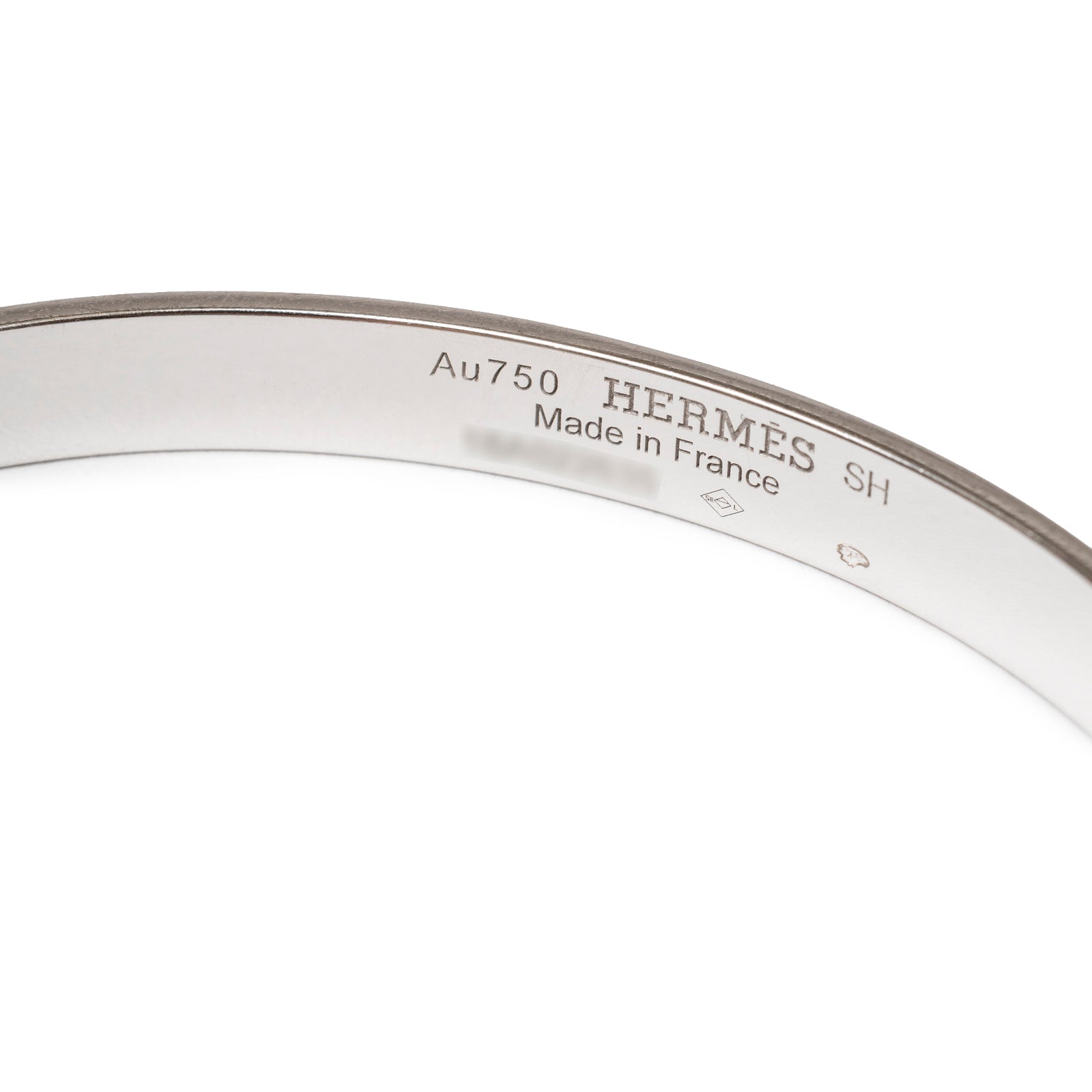 Close-up of inner band engraving on Hermès Collier de Chien Bracelet Small Model 18K White Gold Pink Sapphire showing gold purity and origin marks