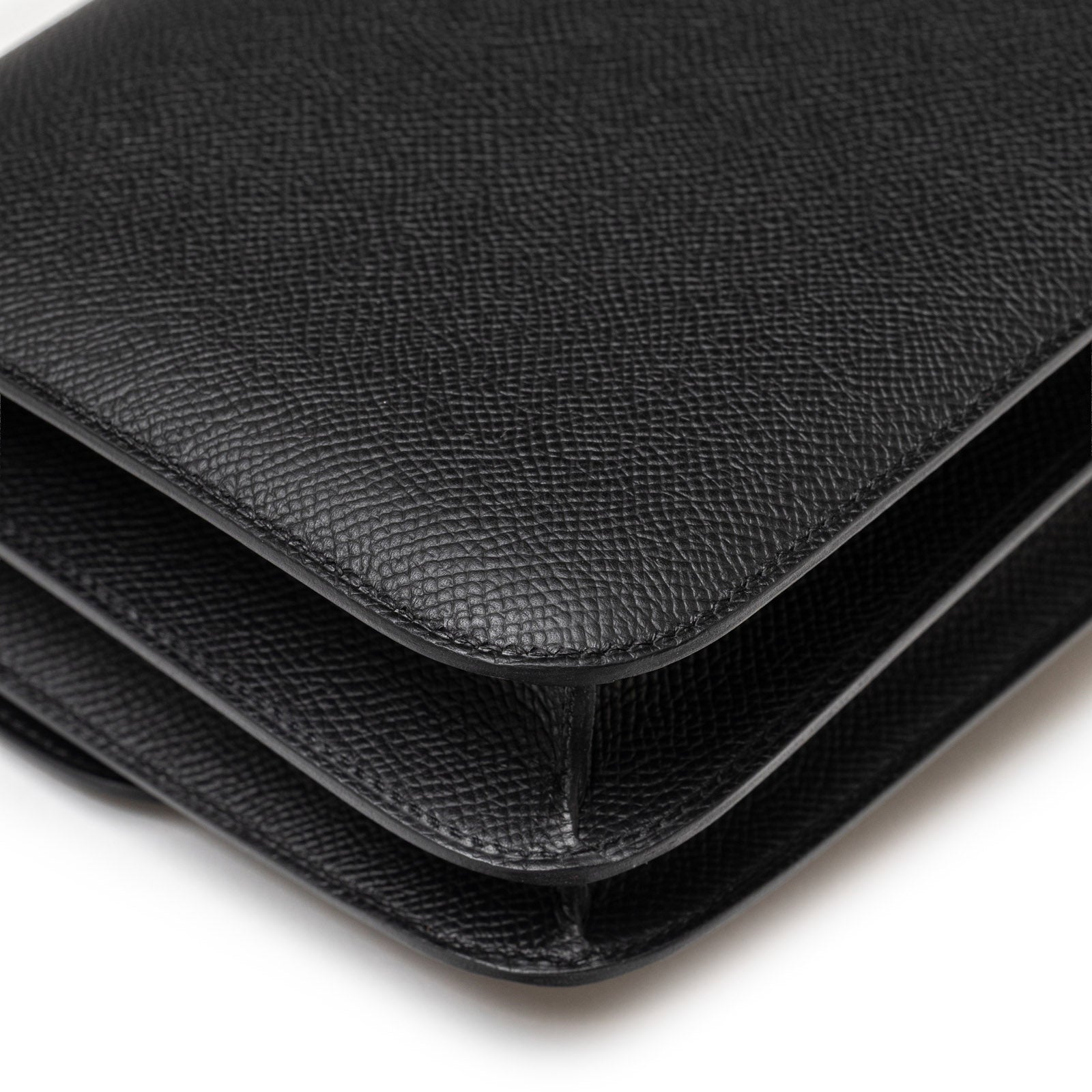 Close-up angled view of Hermès Constance 18 Black Epsom Palladium Hardware showing textured leather edges