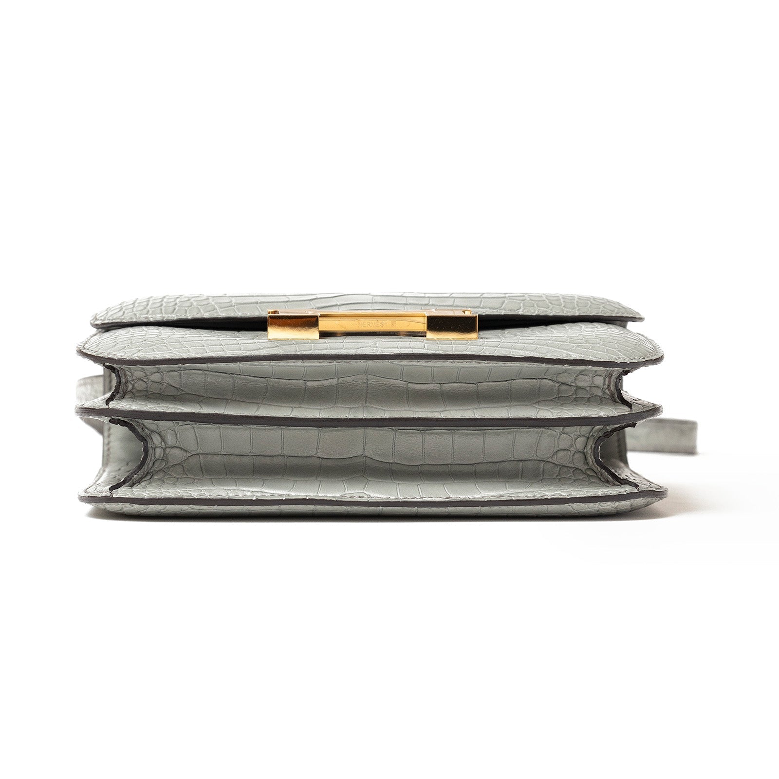 Side view of Hermès Mini Constance 18 Gris Ciment Matte Alligator Gold Hardware showing compartments and texture