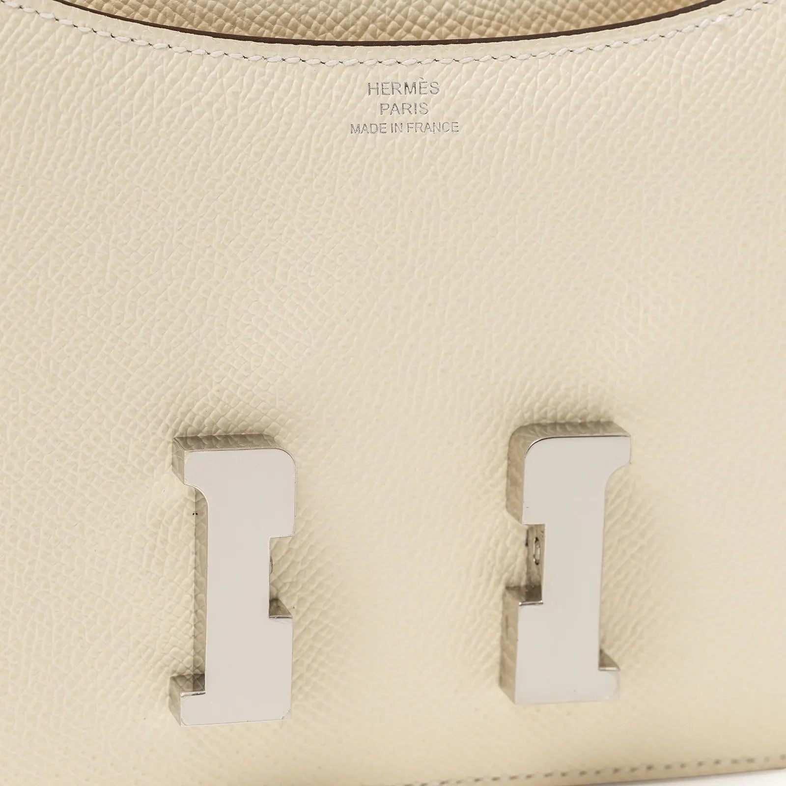 Close-up of Hermès Mini Constance 18 Nata Epsom Palladium Hardware showing textured leather and metal clasp detail