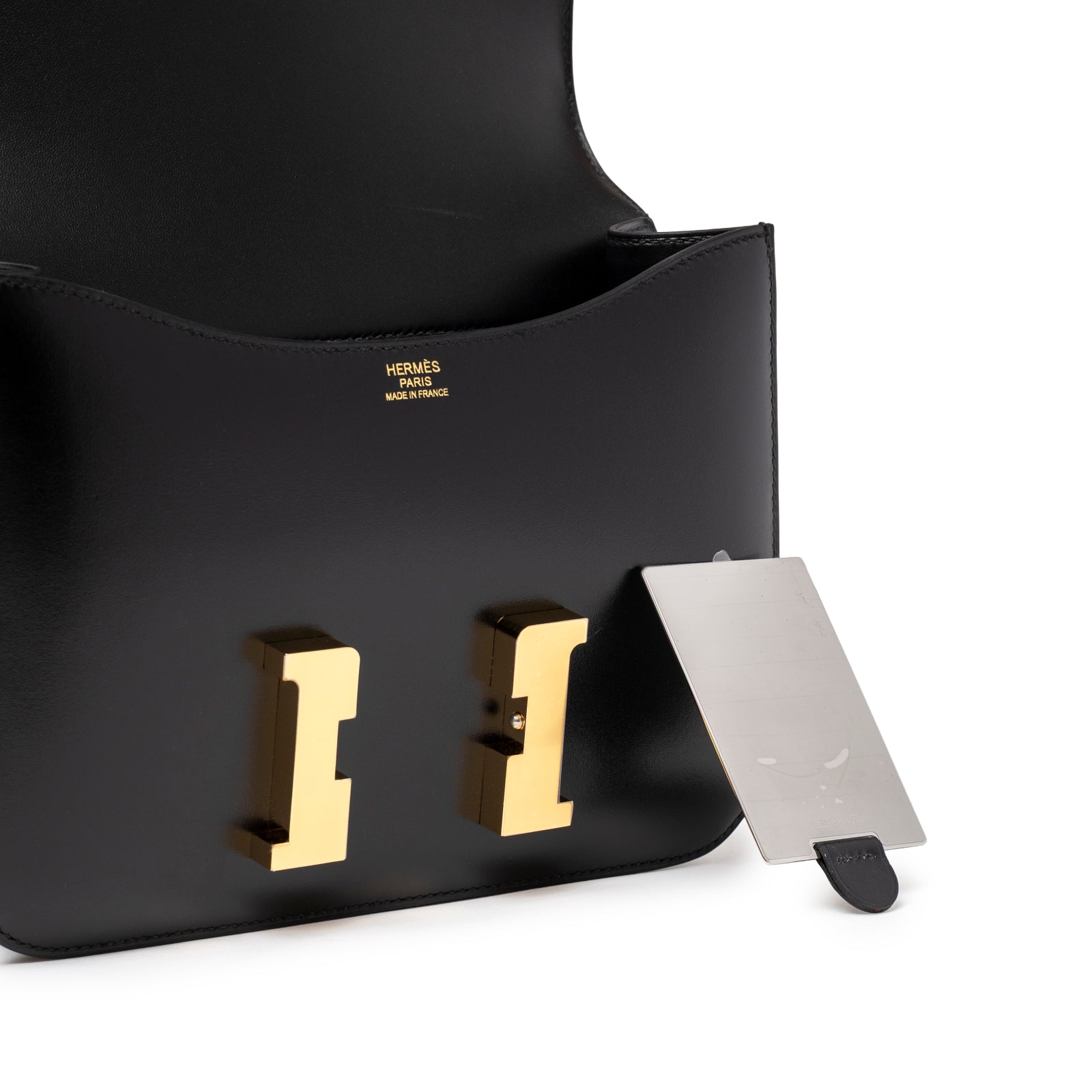Interior view of Hermès Constance 24 Black Box Gold Hardware showing gold clasp and logo embossing inside flap
