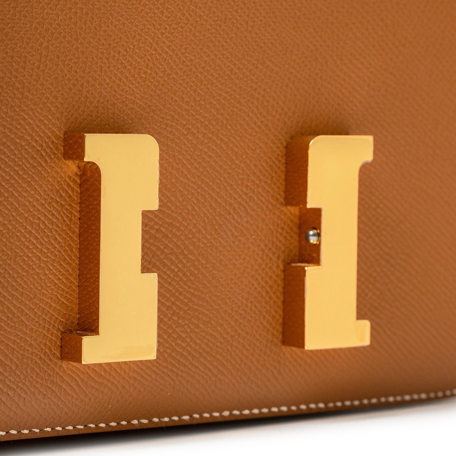 Close-up of gold hardware clasp on Hermès Constance 24 Gold Epsom Gold Hardware bag with textured leather detail