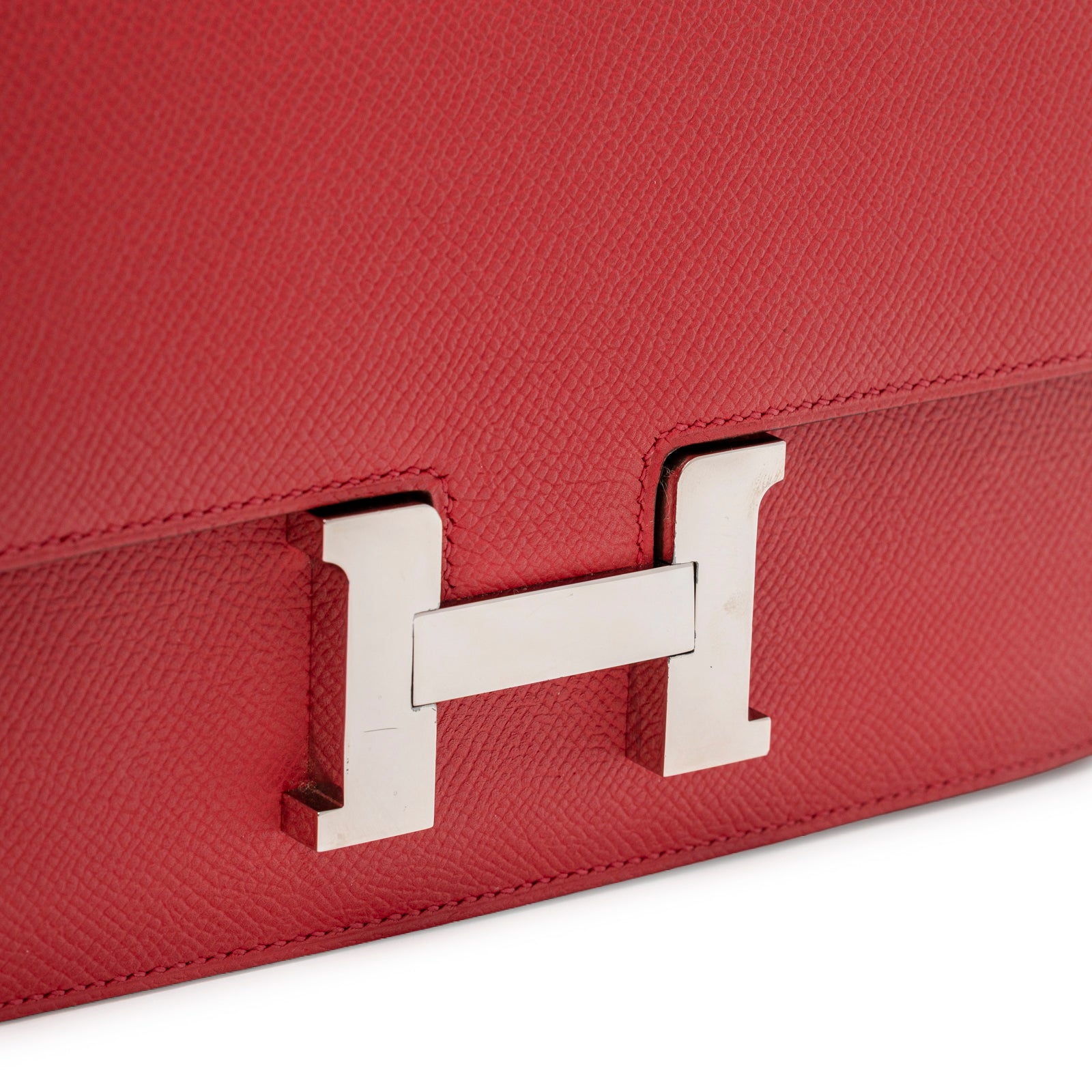Close-up of Hermès Constance Elan Rouge Epsom Palladium Hardware showing textured leather and signature "H" clasp detail