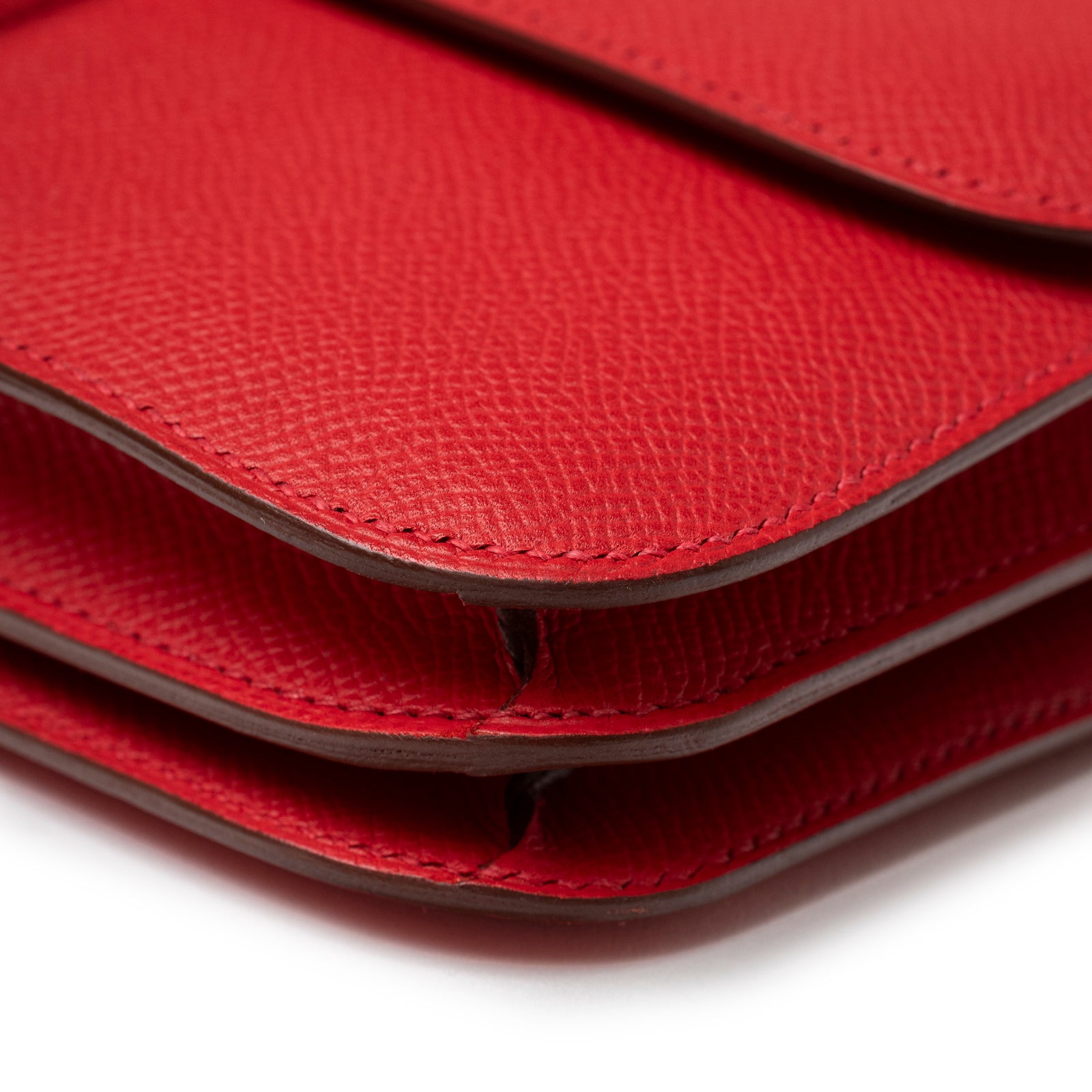 Close-up of layered red textured leather edges on Hermès Constance Elan Rouge Epsom Palladium Hardware handbag