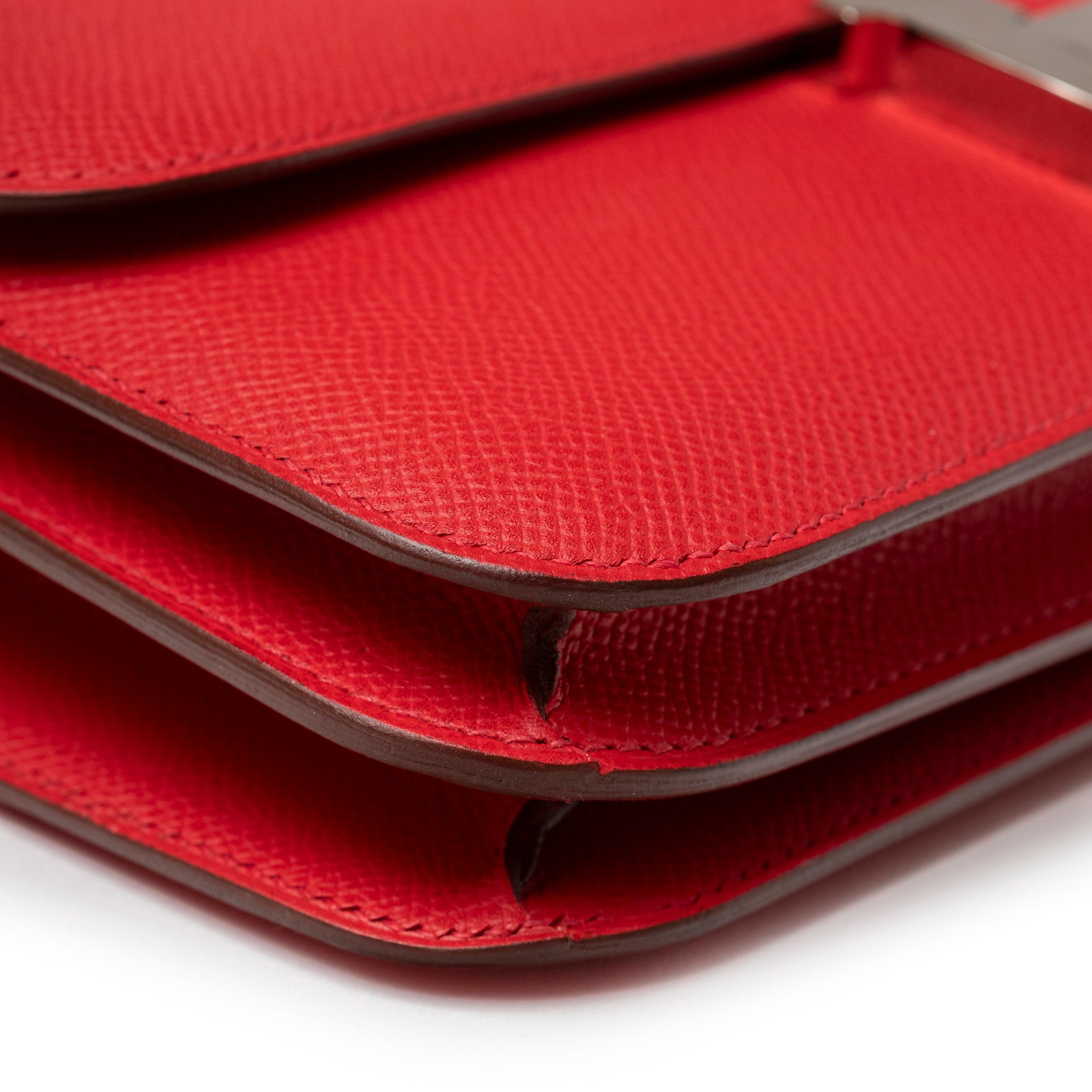 Close-up of Hermès Constance Elan Rouge Epsom Palladium Hardware showing textured red leather and layered flap edges.