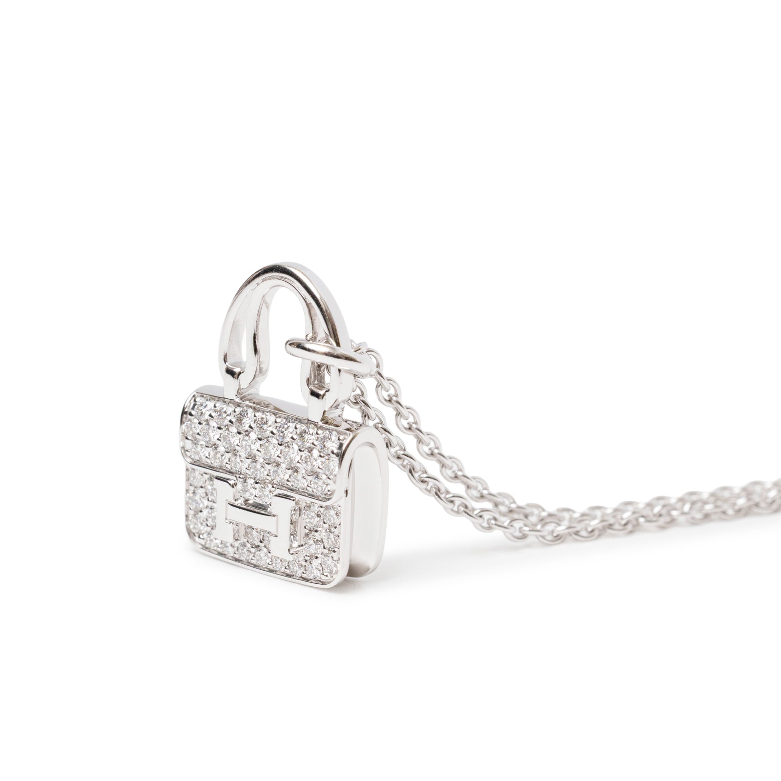 Close-up of Hermès Constance Pendant 18K White Gold and Diamonds shaped like a small handbag with chain detail.