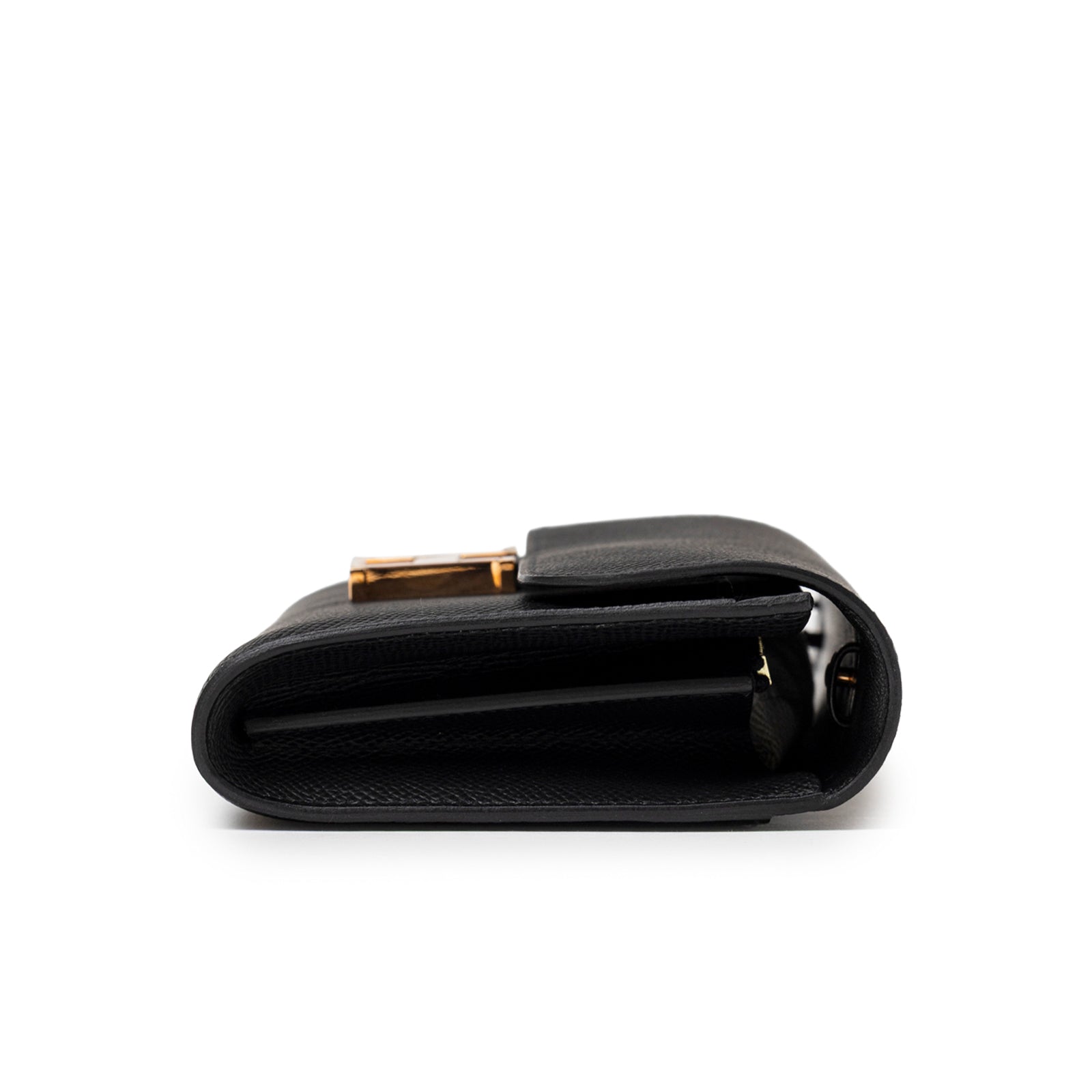 Side profile of Hermès Constance To Go Wallet Black Epsom Rose Gold Hardware showing folded leather edges and clasp glimpse
