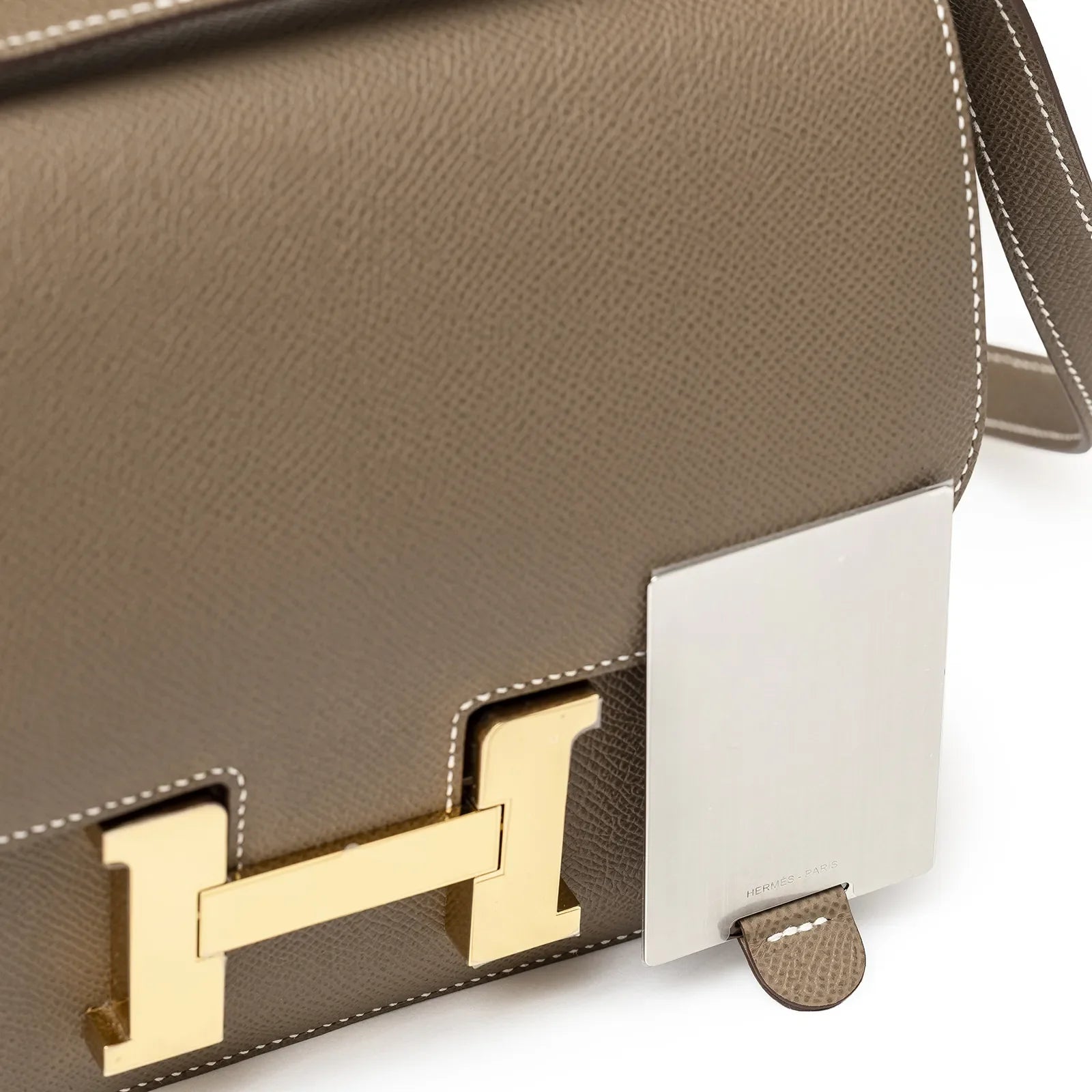 Close-up of gold hardware clasp and Etoupe Epsom leather on Hermès Constance 24 Etoupe Epsom Gold Hardware handbag