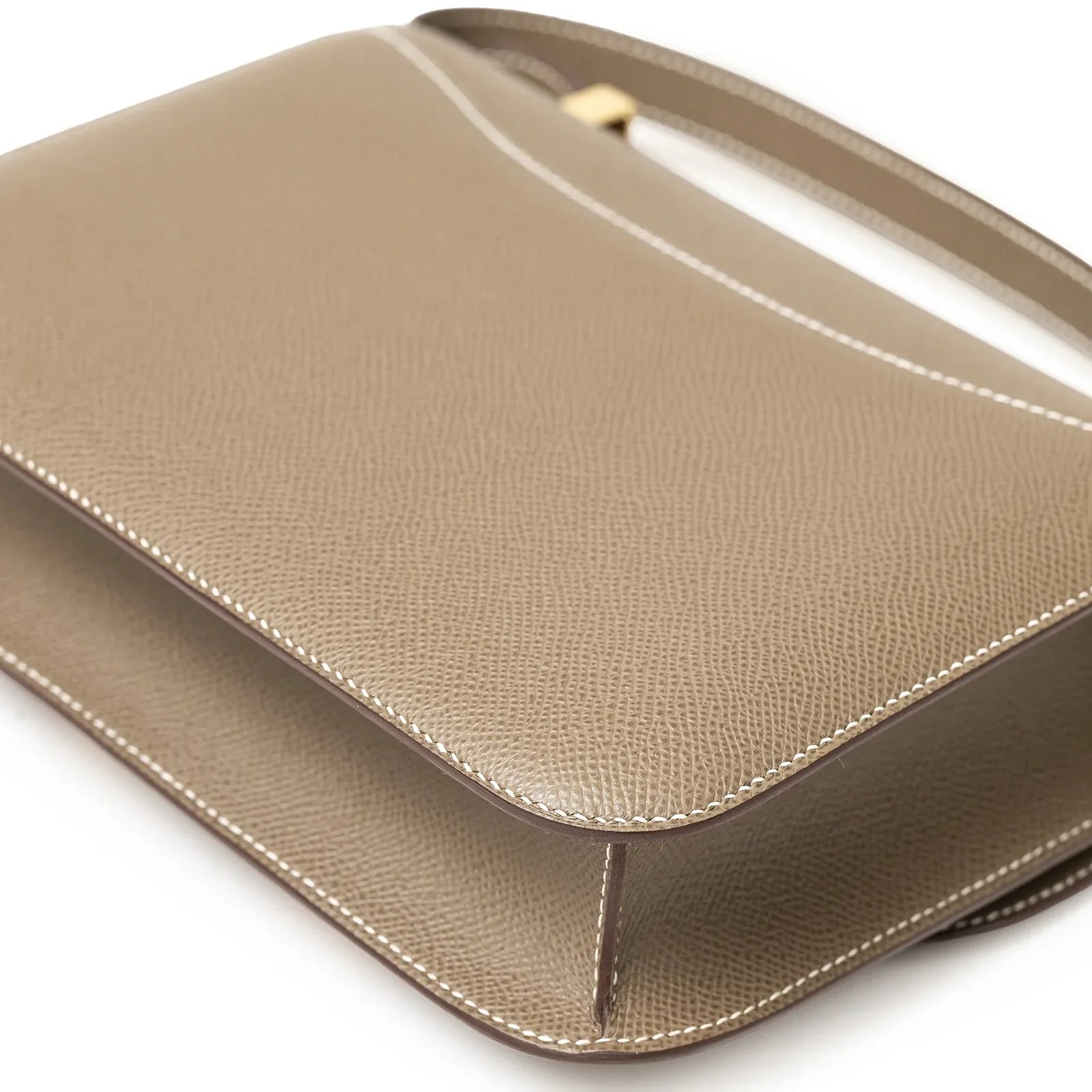 Angled view of Hermès Constance 24 Etoupe Epsom Gold Hardware showing textured leather and edge stitching detail