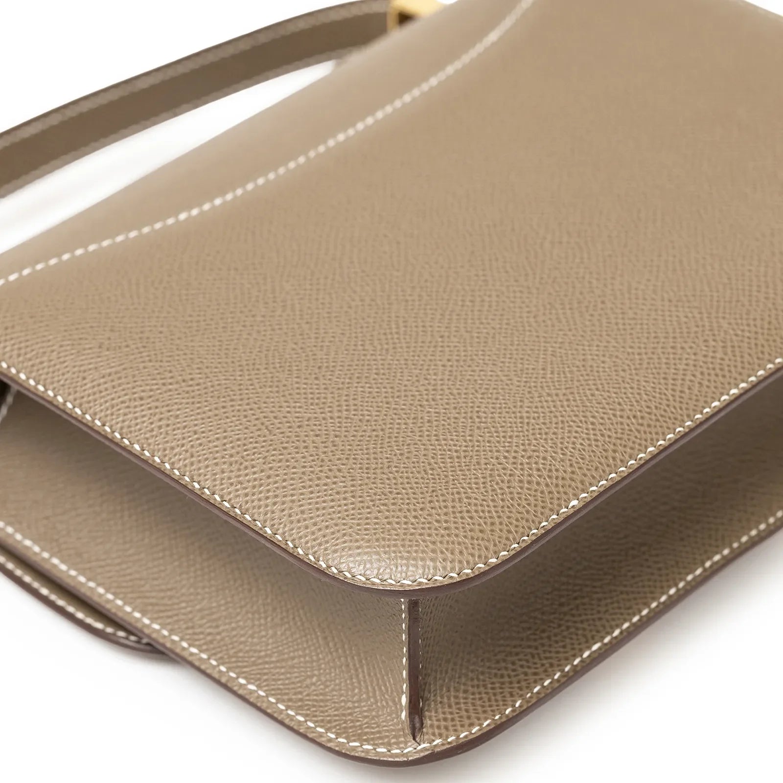 Close-up angled shot of Hermès Constance 24 Etoupe Epsom Gold Hardware showing grainy leather texture and stitching details