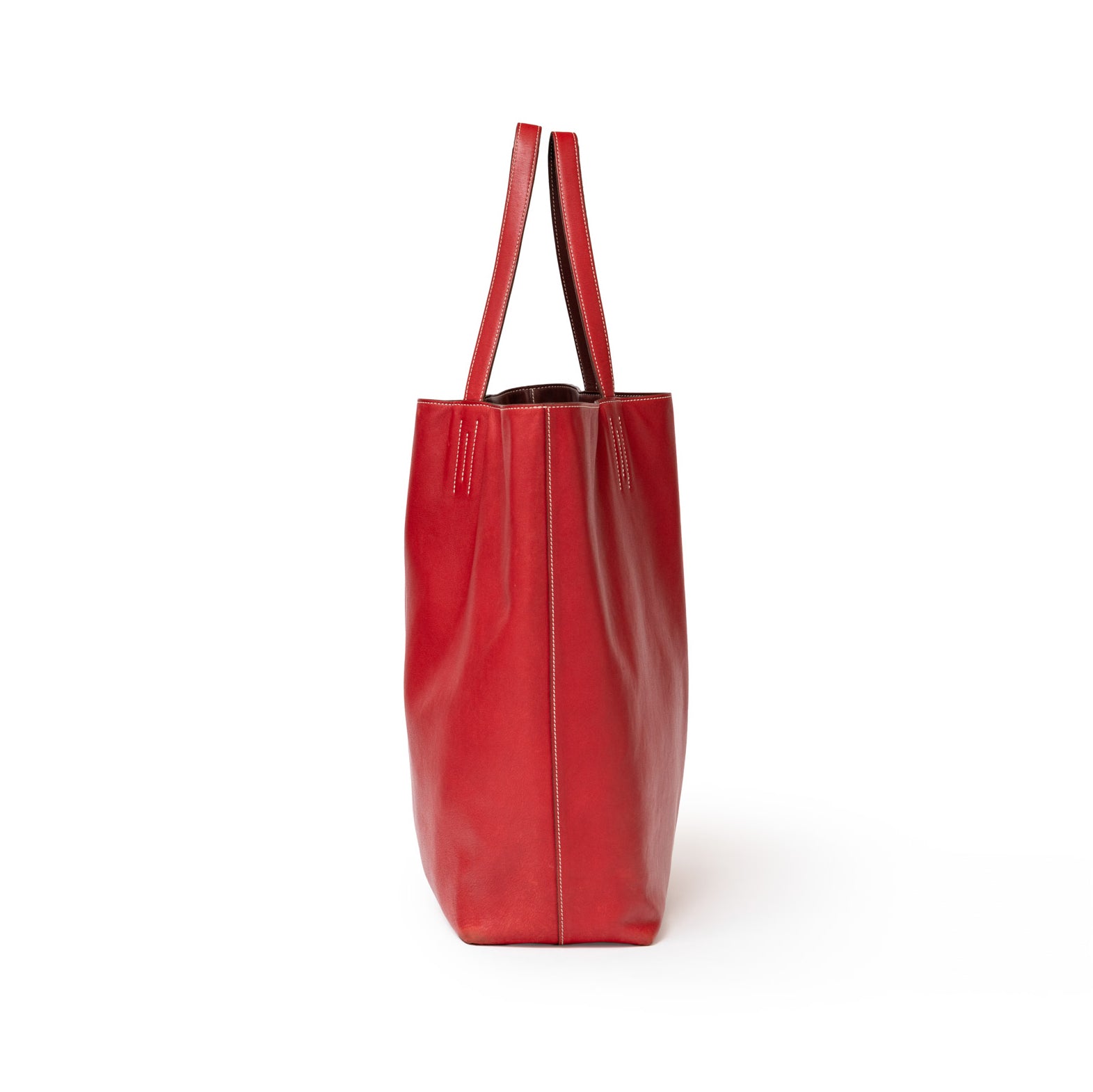 Side view of Hermès Double Sens 45 Rouge/Bicolor Swift tote bag showing sleek red leather and handles