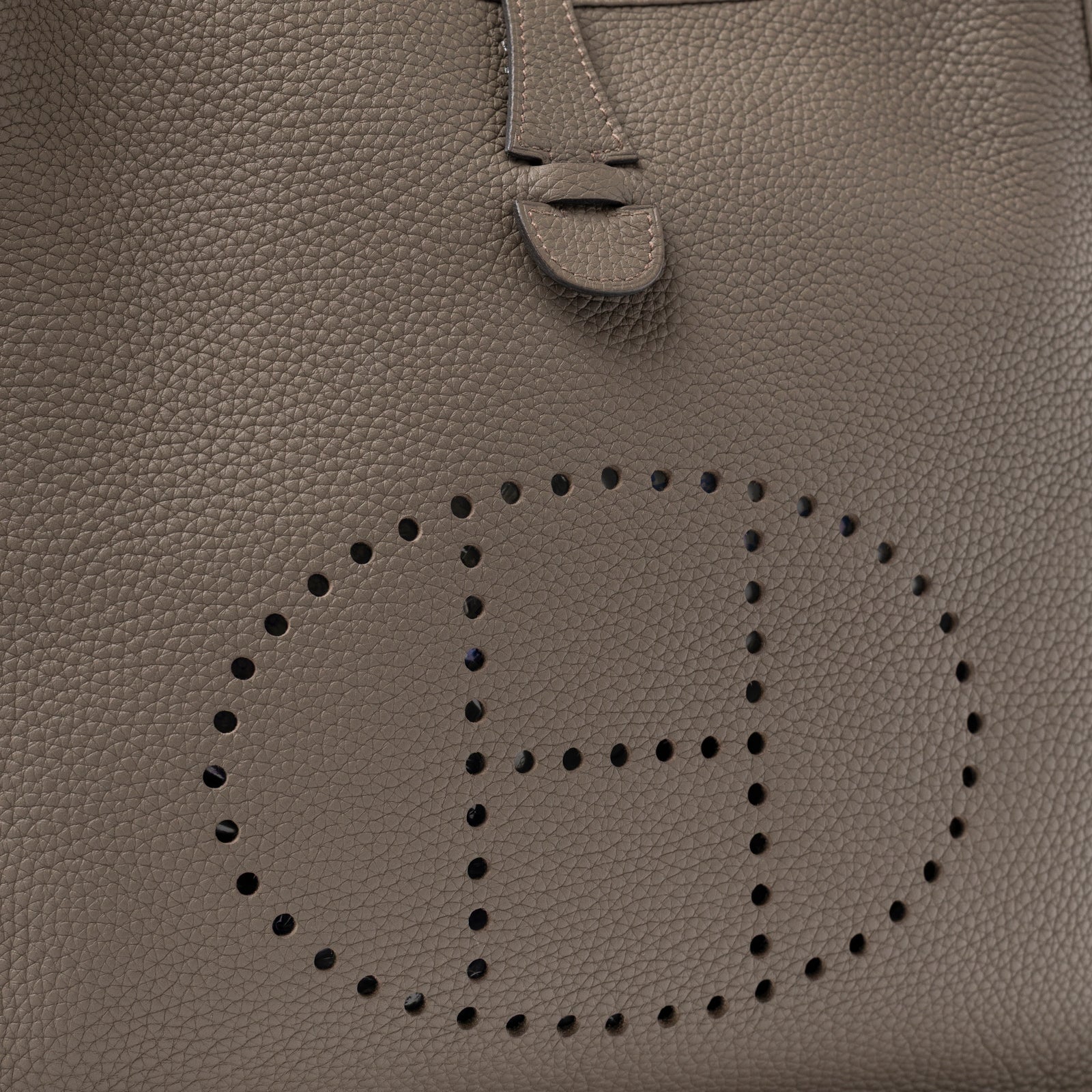Close-up of Hermès Evelyne PM 29 Etain Clemence Palladium Hardware featuring perforated H logo and textured leather detail