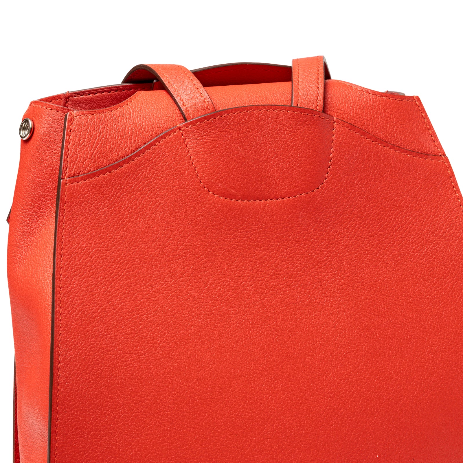 Close-up of textured leather detail and top handles on Hermès Gr24 Backpack Rouge Tomate Evercolor Palladium Hardware