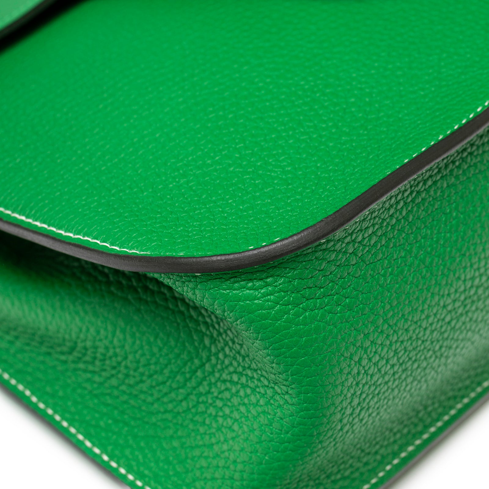 Close-up showing vibrant green pebbled leather with white stitching and edge detailing on Hermès Halzan 31 Bambou Clemence Palladium Hardware