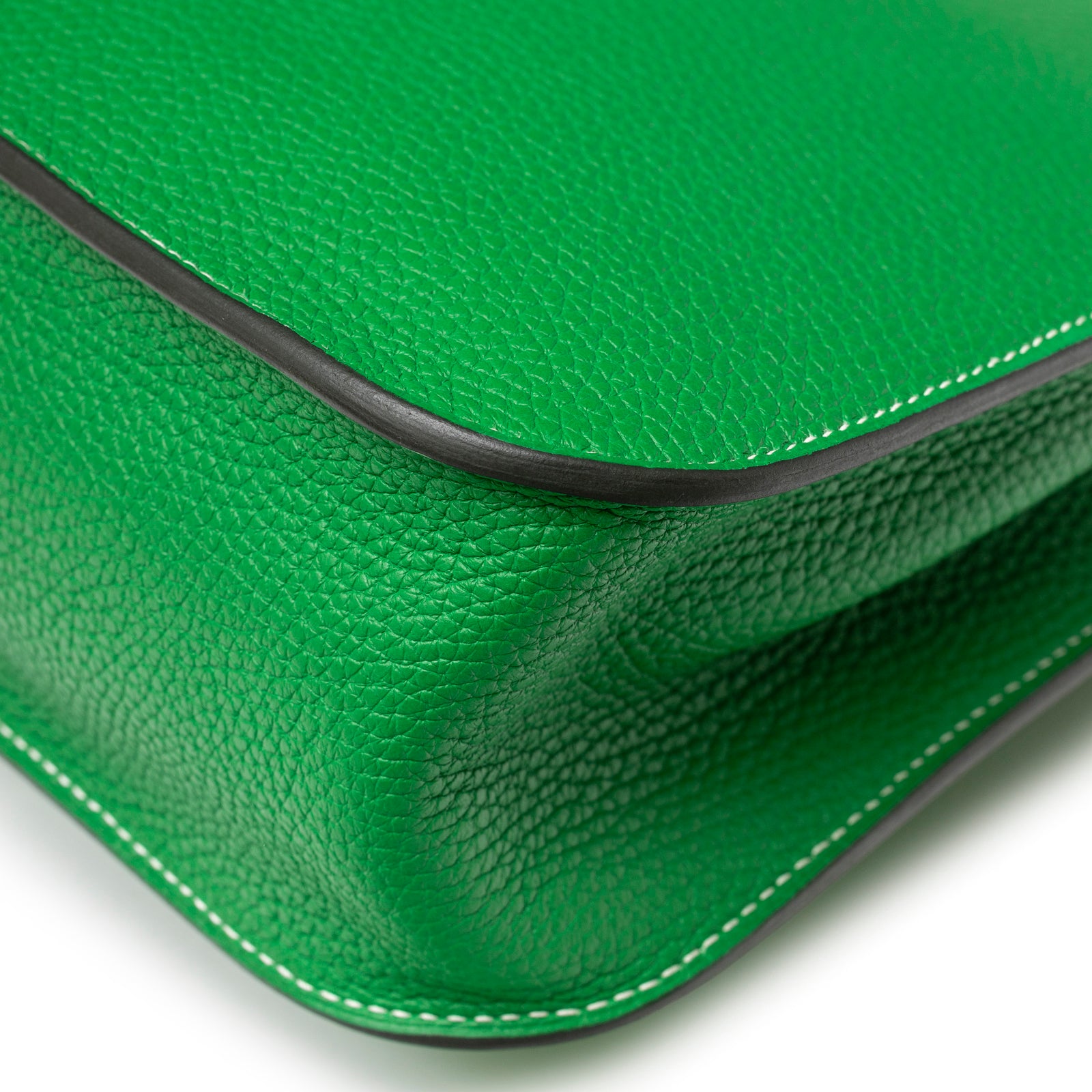Close-up of corner and white stitching on Hermès Halzan 31 Bambou Clemence Palladium Hardware showing vibrant green leather texture