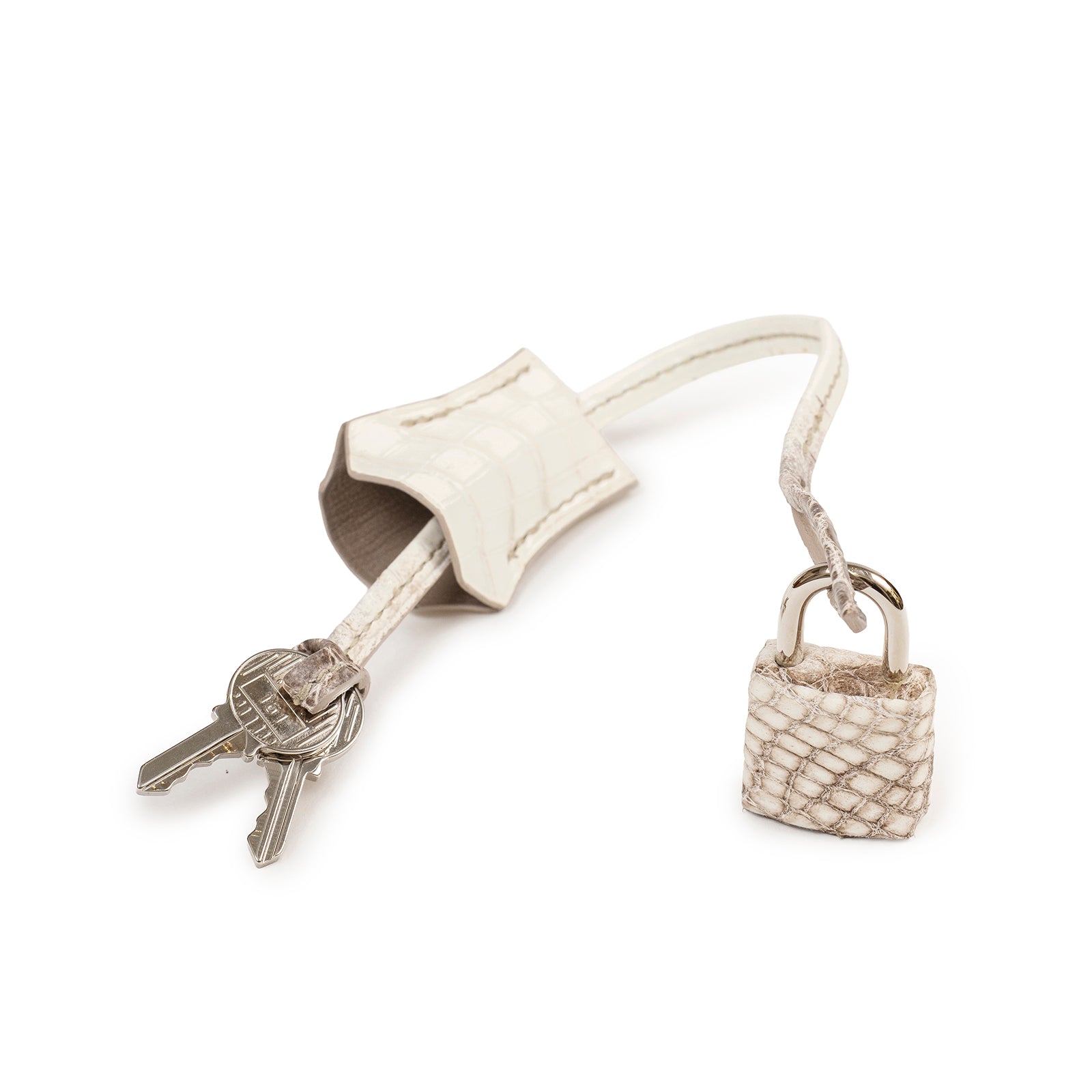 Close-up of Hermès Himalaya Birkin 30 Matte Niloticus Crocodile Palladium Hardware lock and two keys detail, side angle view