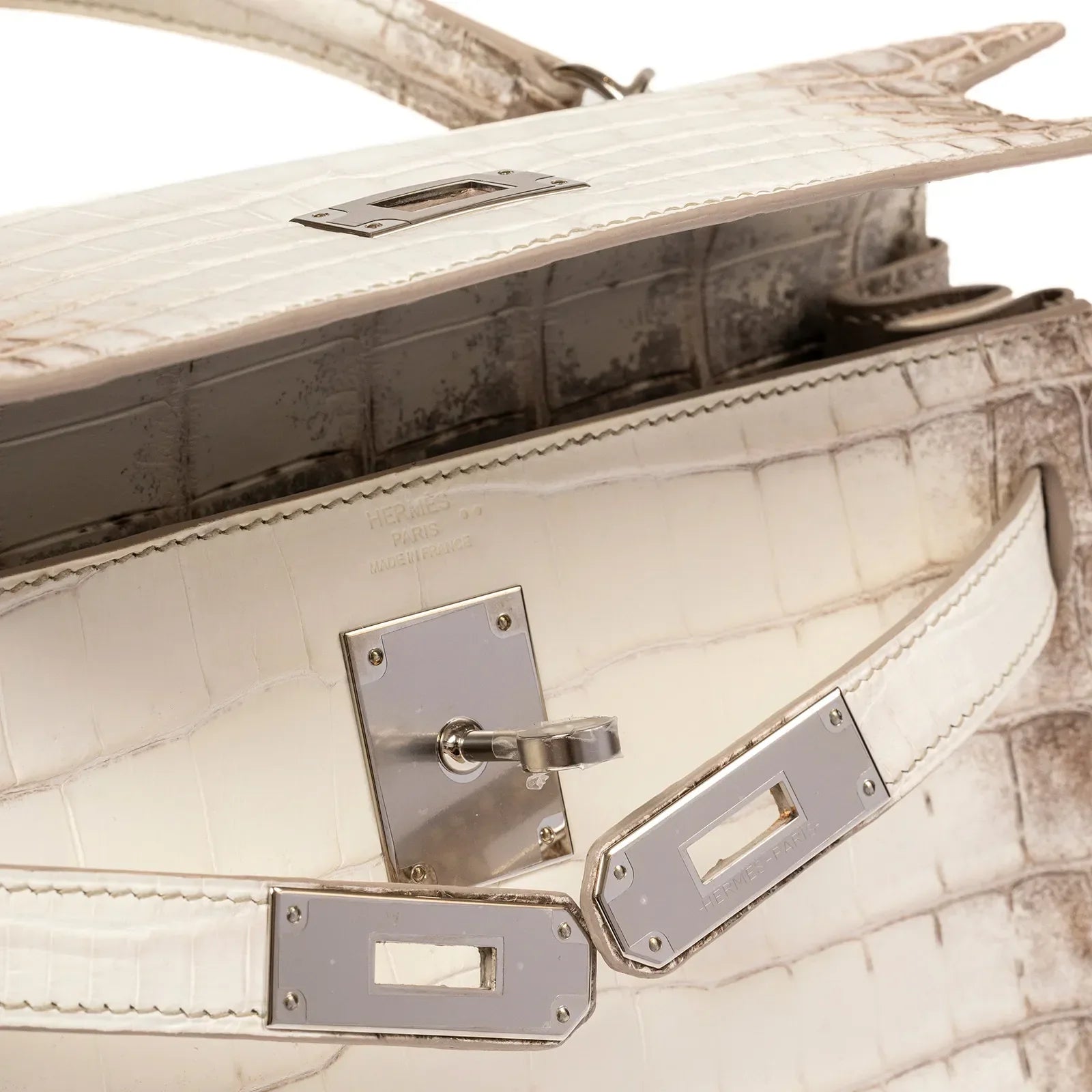 Close-up of Hermès Himalaya Kelly 28 Retourne Blanc Matte Niloticus Crocodile Palladium Hardware showing flap, silver hardware, and stitching details.