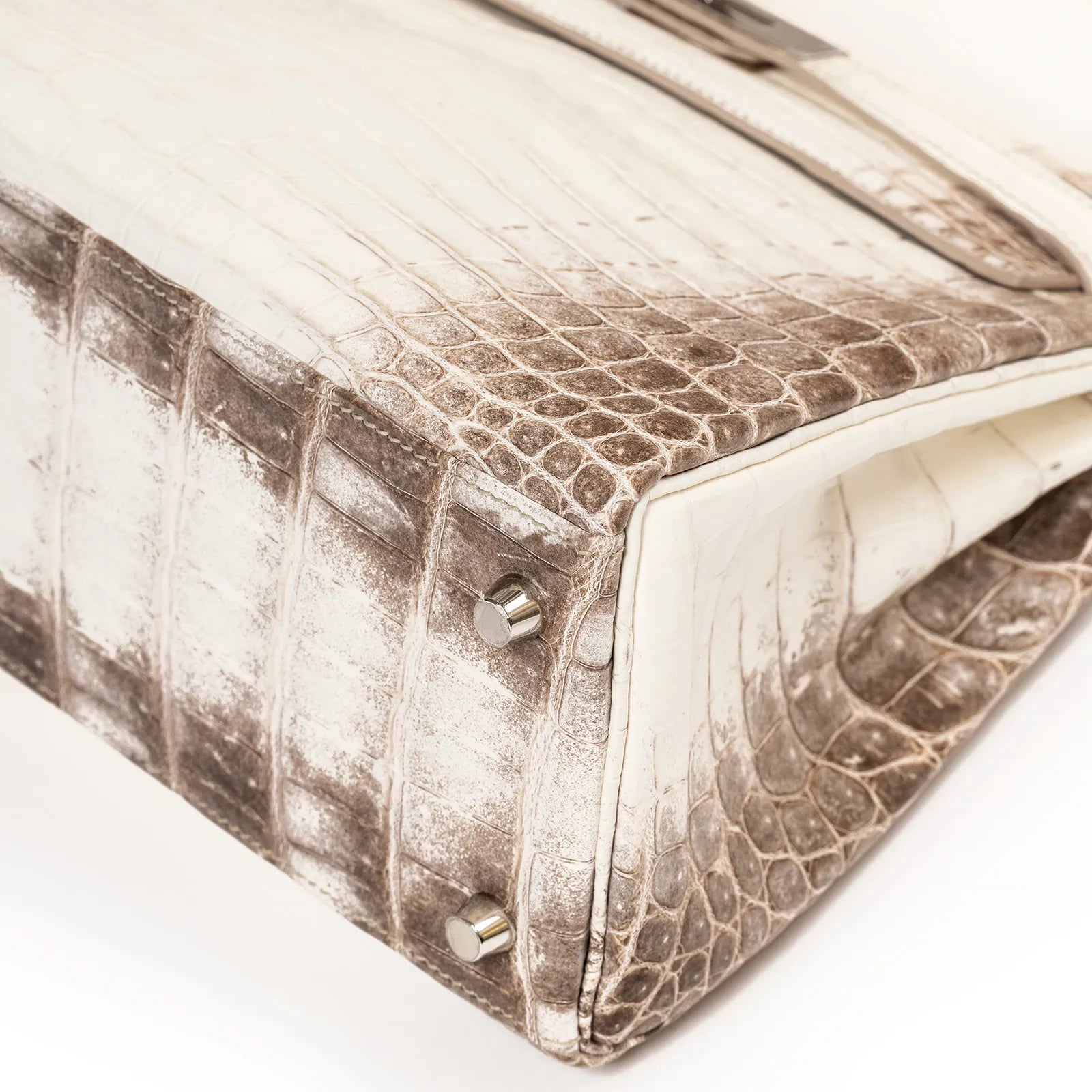 Bottom view of Hermès Himalaya Kelly 28 Retourne Blanc Matte Niloticus Crocodile Palladium Hardware bag with metal feet accents.