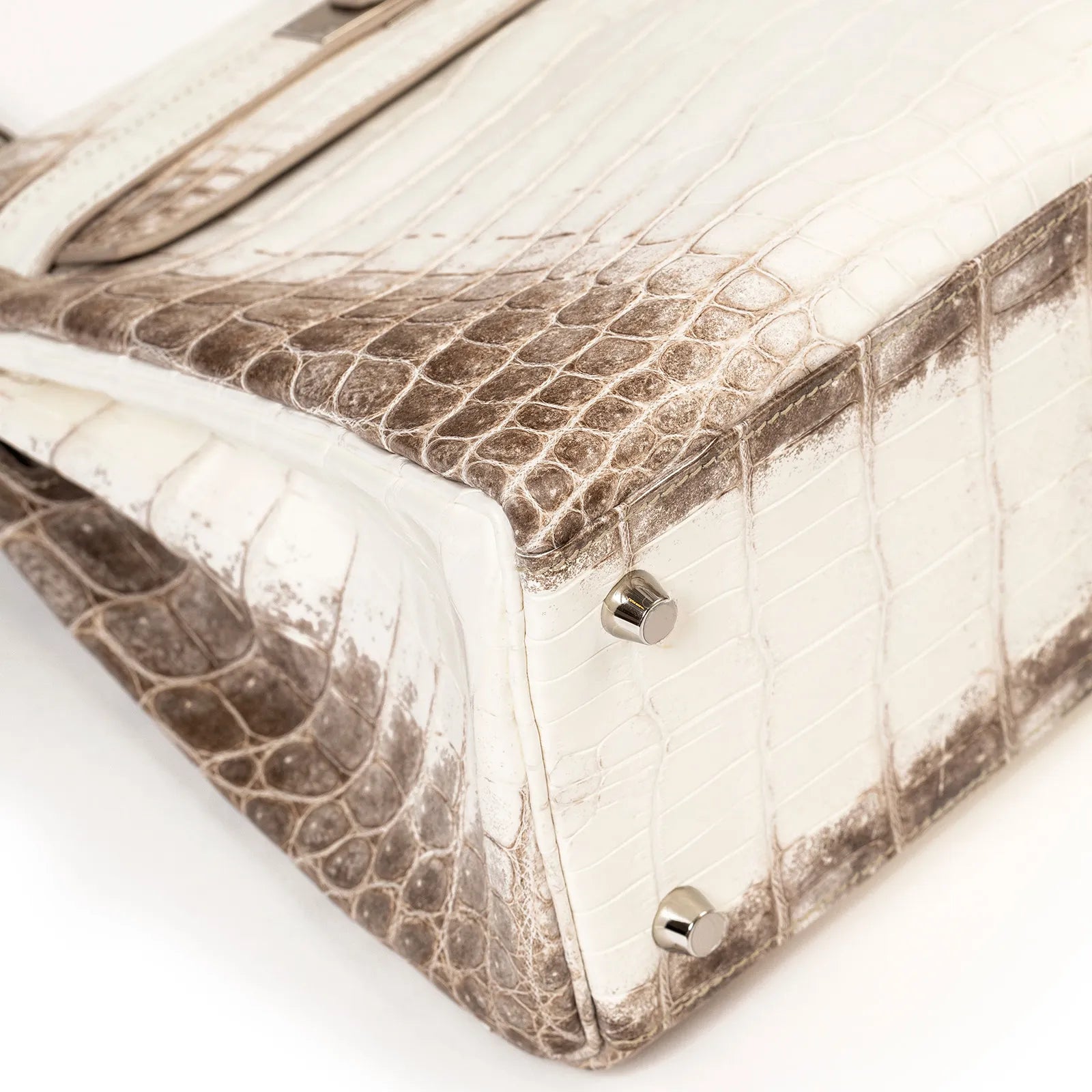 Bottom view of Hermès Himalaya Kelly 28 Retourne Blanc Matte Niloticus Crocodile Palladium Hardware handbag with metal studs, showcasing detailed texture.