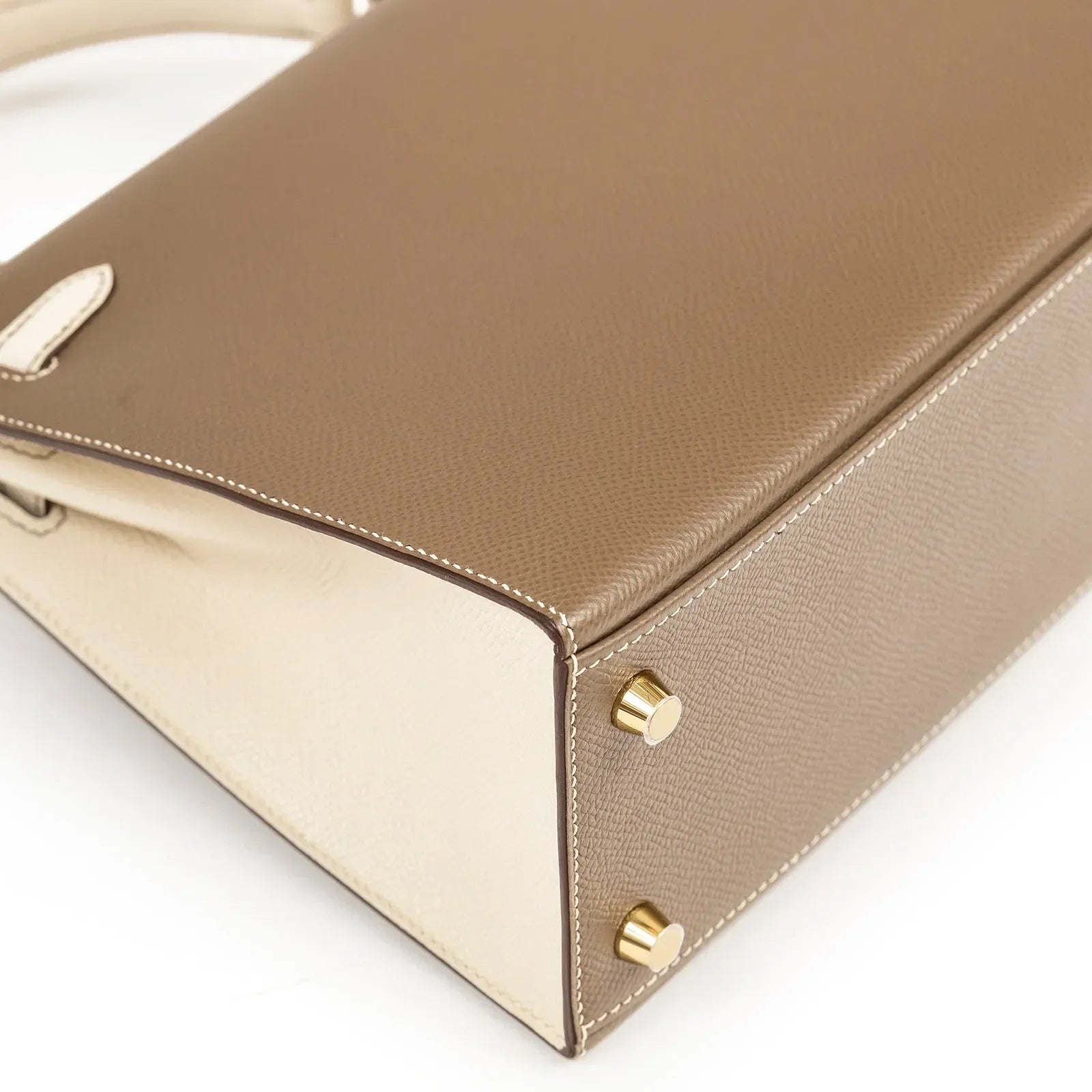 Close-up of bottom corner and gold hardware feet on Hermès Horseshoe Kelly 25 Sellier Etoupe/Craie Epsom Brushed Gold Hardware