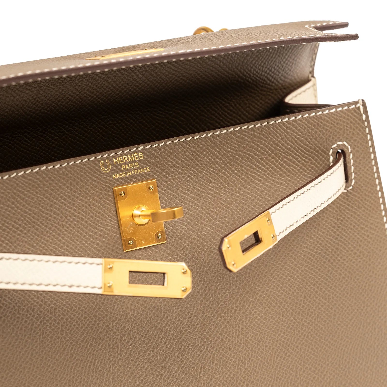 Close-up interior view of Hermès Horseshoe Kelly 25 Sellier Etoupe/Craie Epsom Brushed Gold Hardware clasp and stitching details
