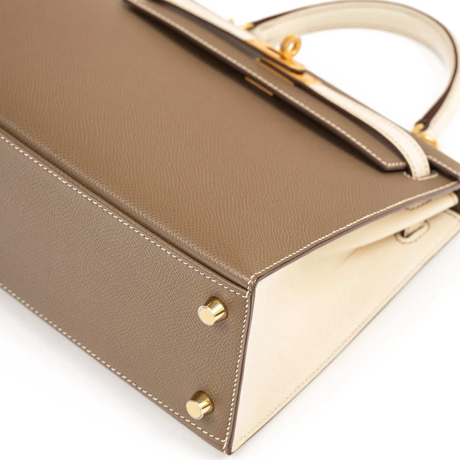 Close-up of bottom corner showing stitching and gold feet on Hermès Horseshoe Kelly 25 Sellier Etoupe/Craie Epsom Brushed Gold Hardware