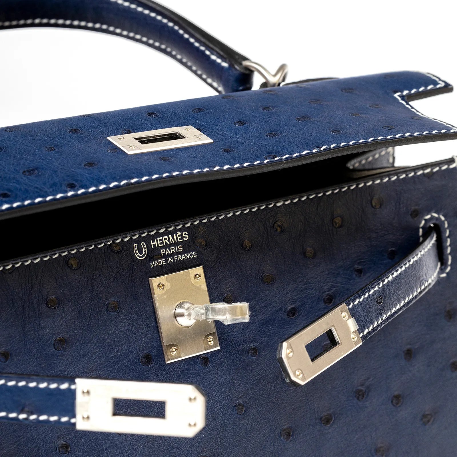 Close-up front view of Hermès Horseshoe Kelly 25 Sellier Ostrich Blue Iris Gris Brushed Palladium Hardware showing lock detail