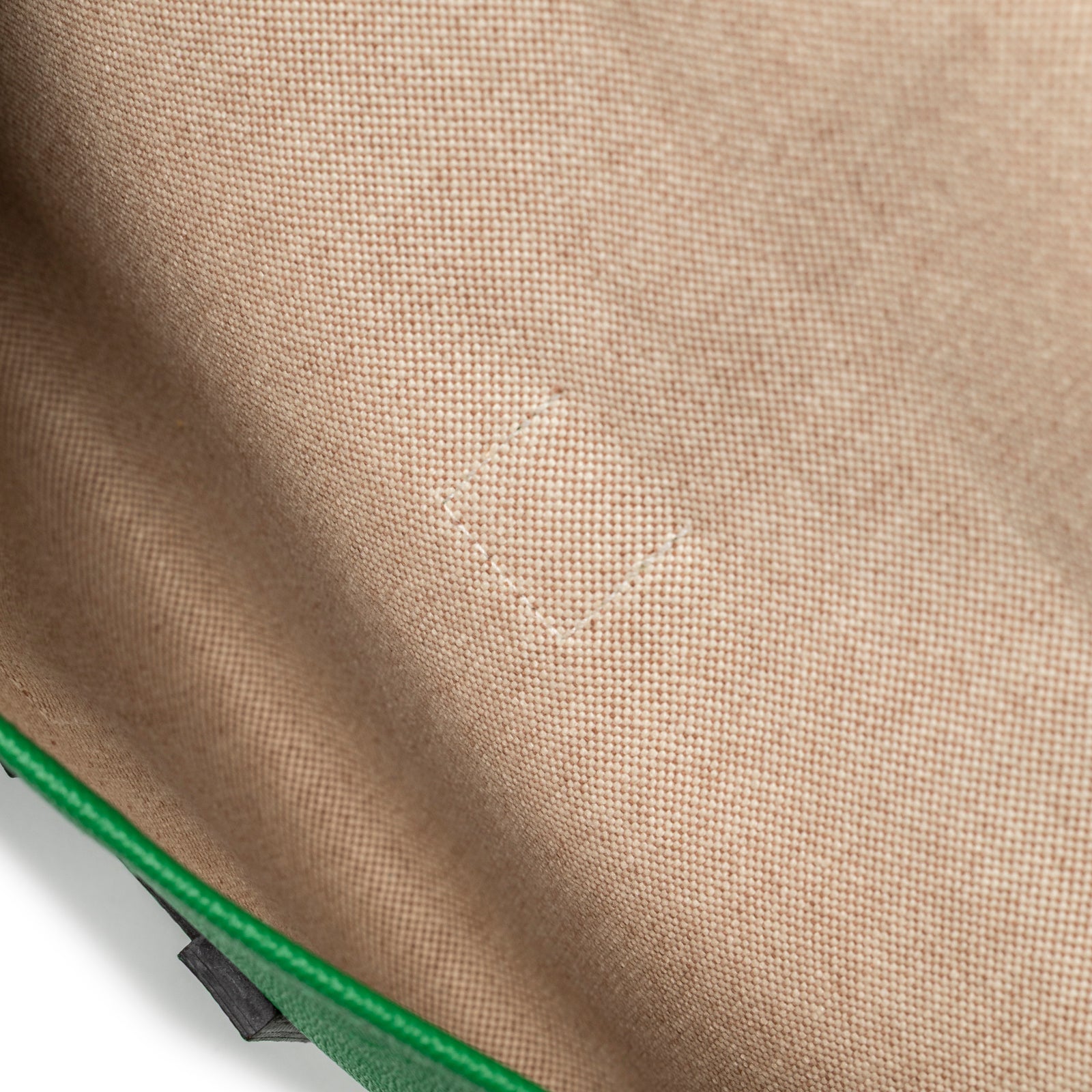 Close-up of interior fabric lining with subtle Hermes stamp inside Hermès Jige PM Bamboo Green Epsom clutch