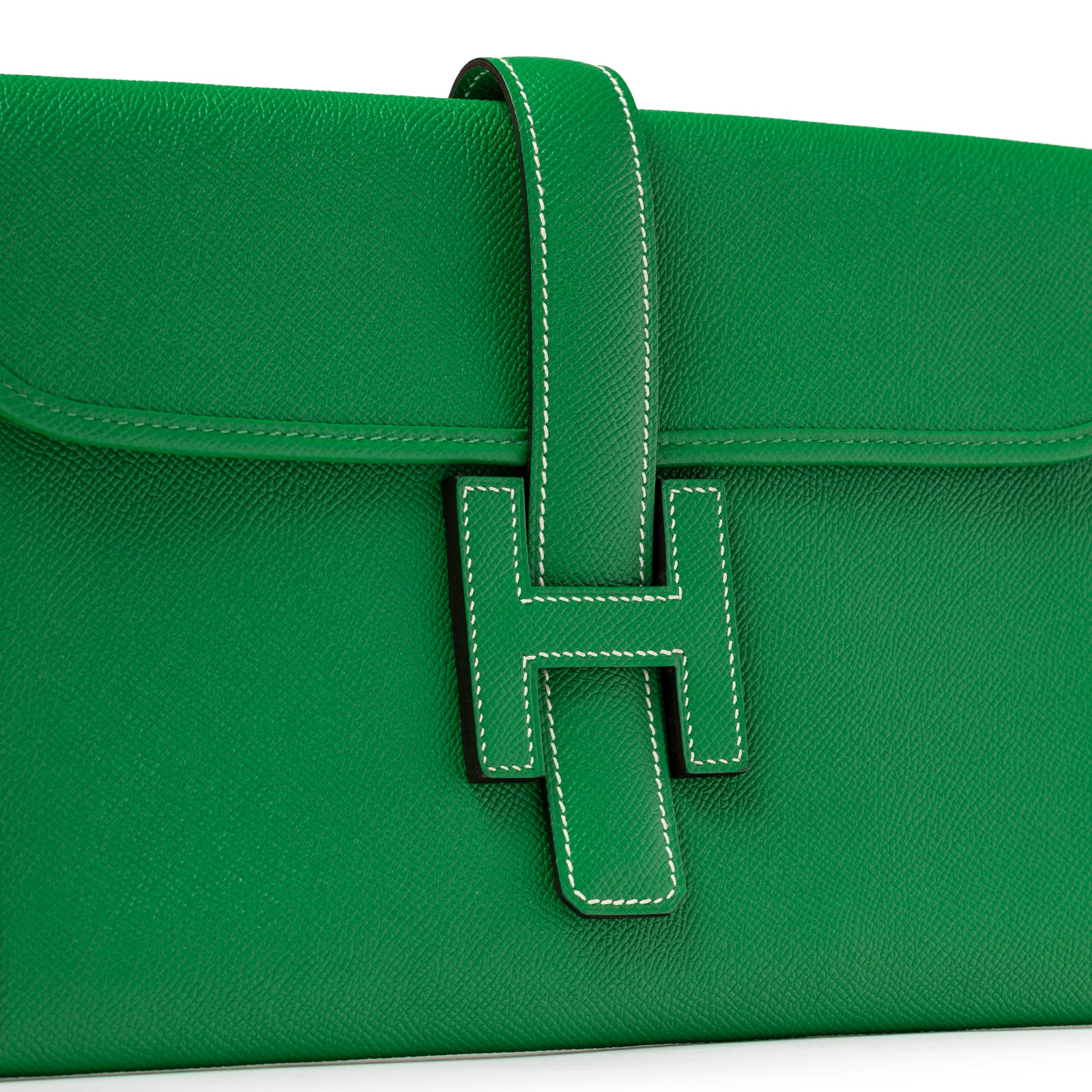 Hermès Jige PM Bamboo Green Epsom close-up of front flap with signature H strap and contrast white stitching detail