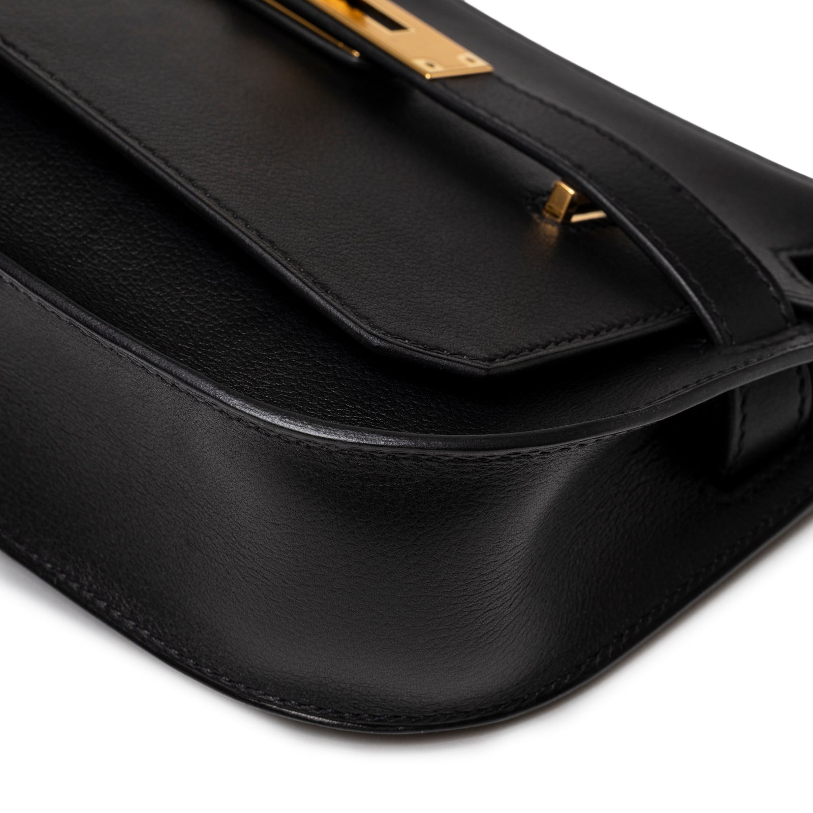 Close-up angled shot of smooth black leather and gold hardware clasp on Hermès Jypsiere Mini Black Evergrain Gold Hardware.