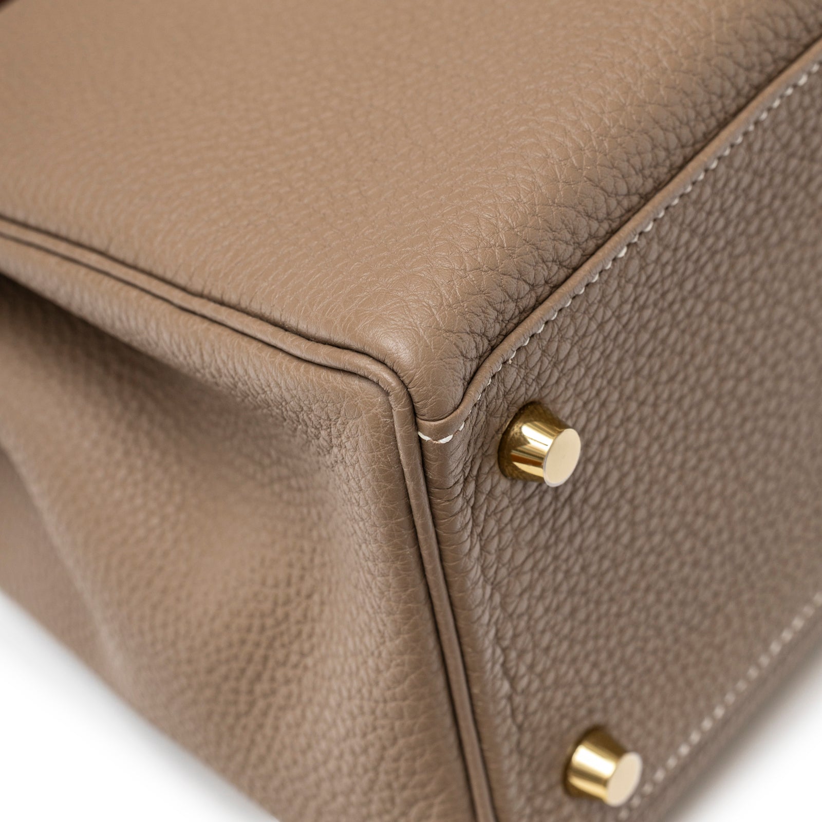 Close-up showing corner, textured Etoupe Togo leather, and gold studs on Hermès Kelly 28 Retourne Etoupe Togo Gold Hardware