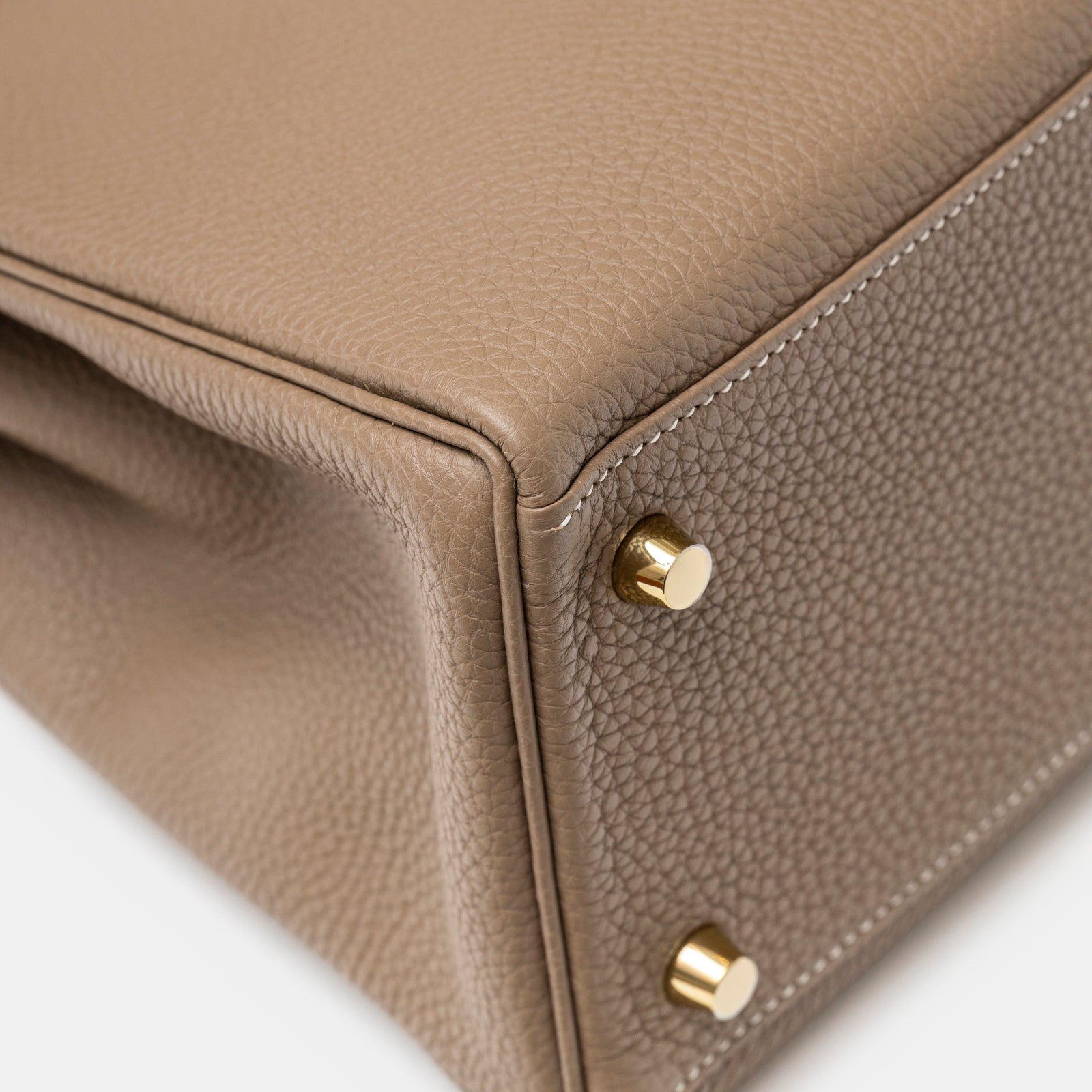 Close-up of bottom corner showing gold studs and textured leather on Hermès Kelly 28 Retourne Etoupe Togo Gold Hardware
