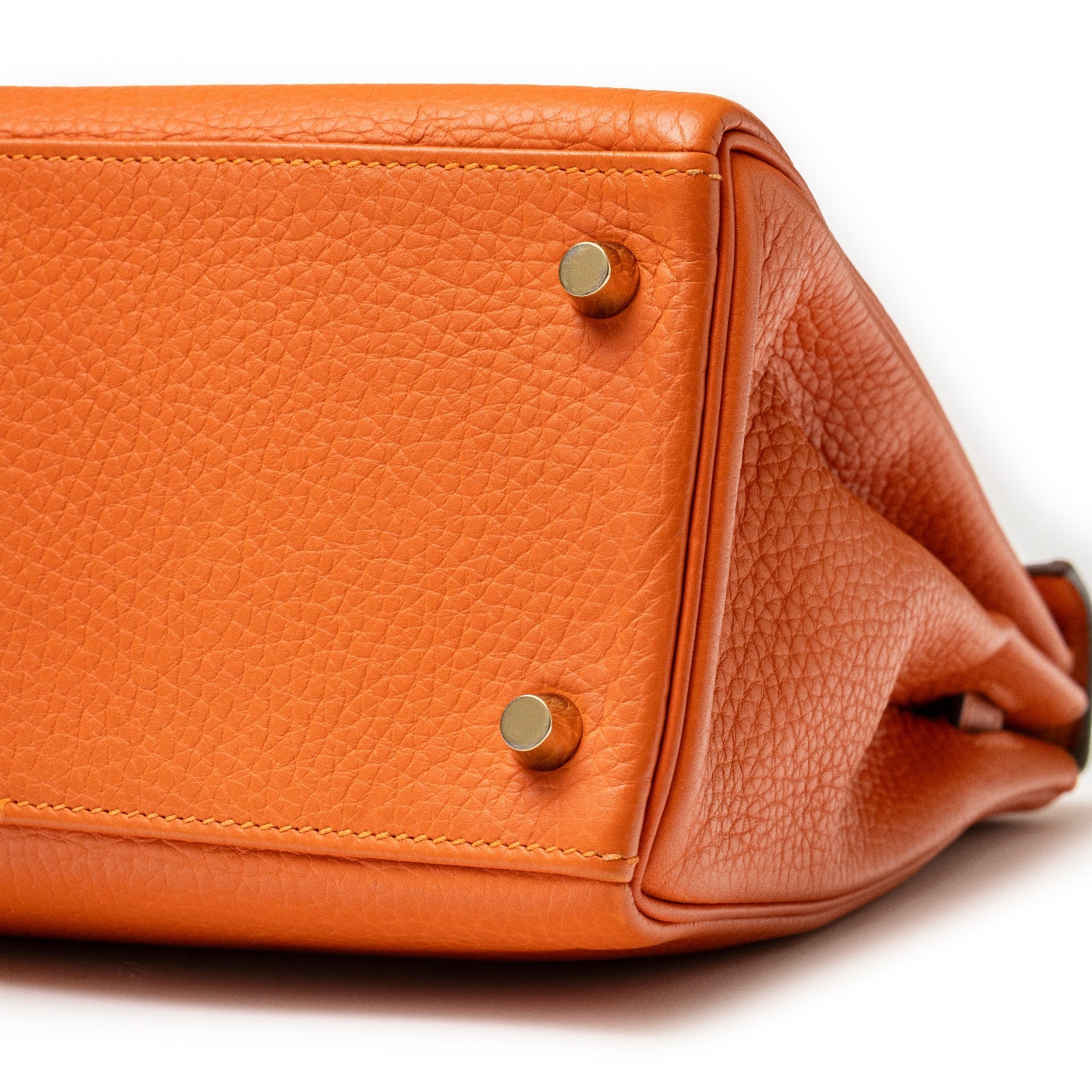 Close-up bottom view of Hermès Kelly 28 Retourne Orange Clemence Gold Hardware showing leather texture and feet