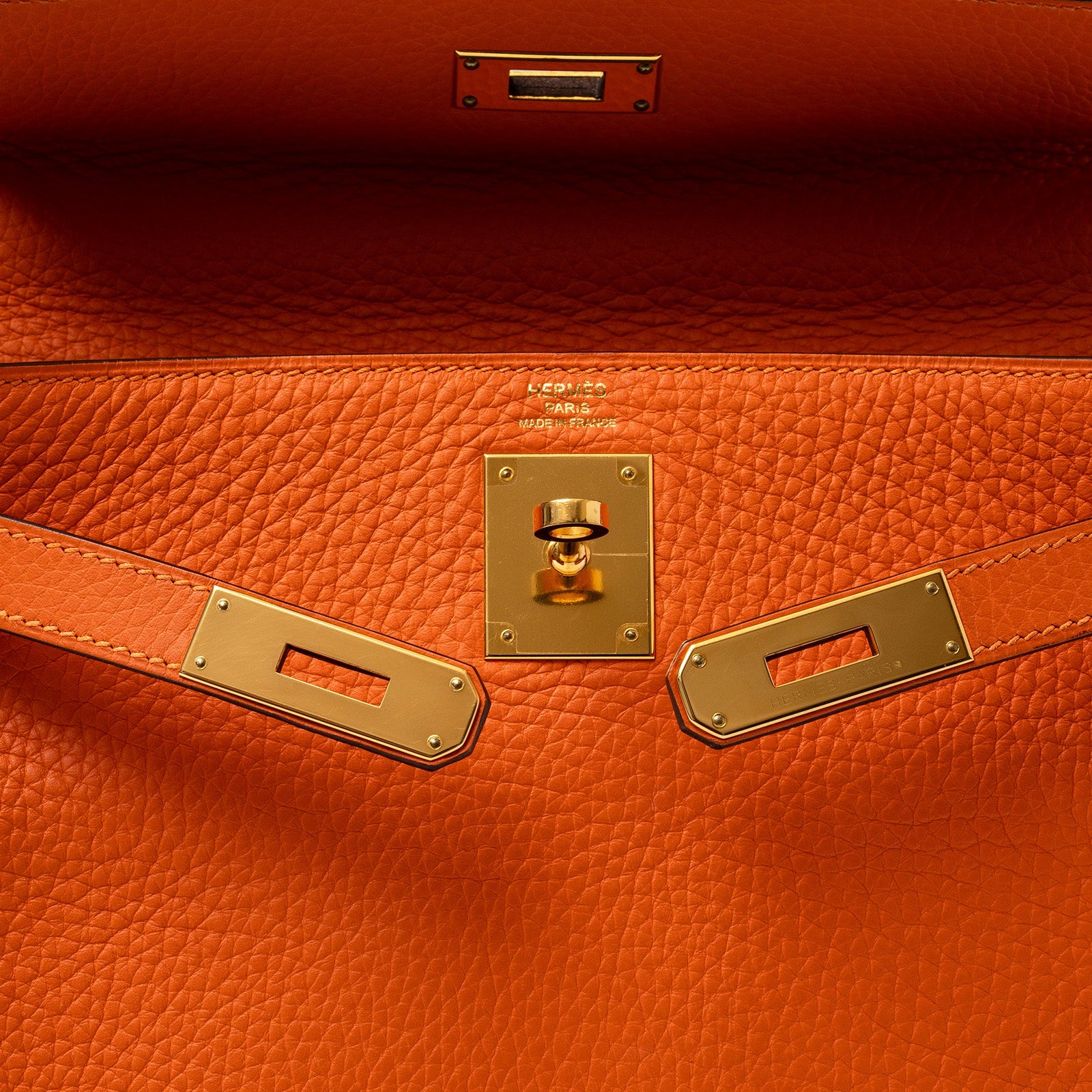 Close-up of interior and gold hardware clasp on Hermès Kelly 28 Retourne Orange Clemence Gold Hardware handbag